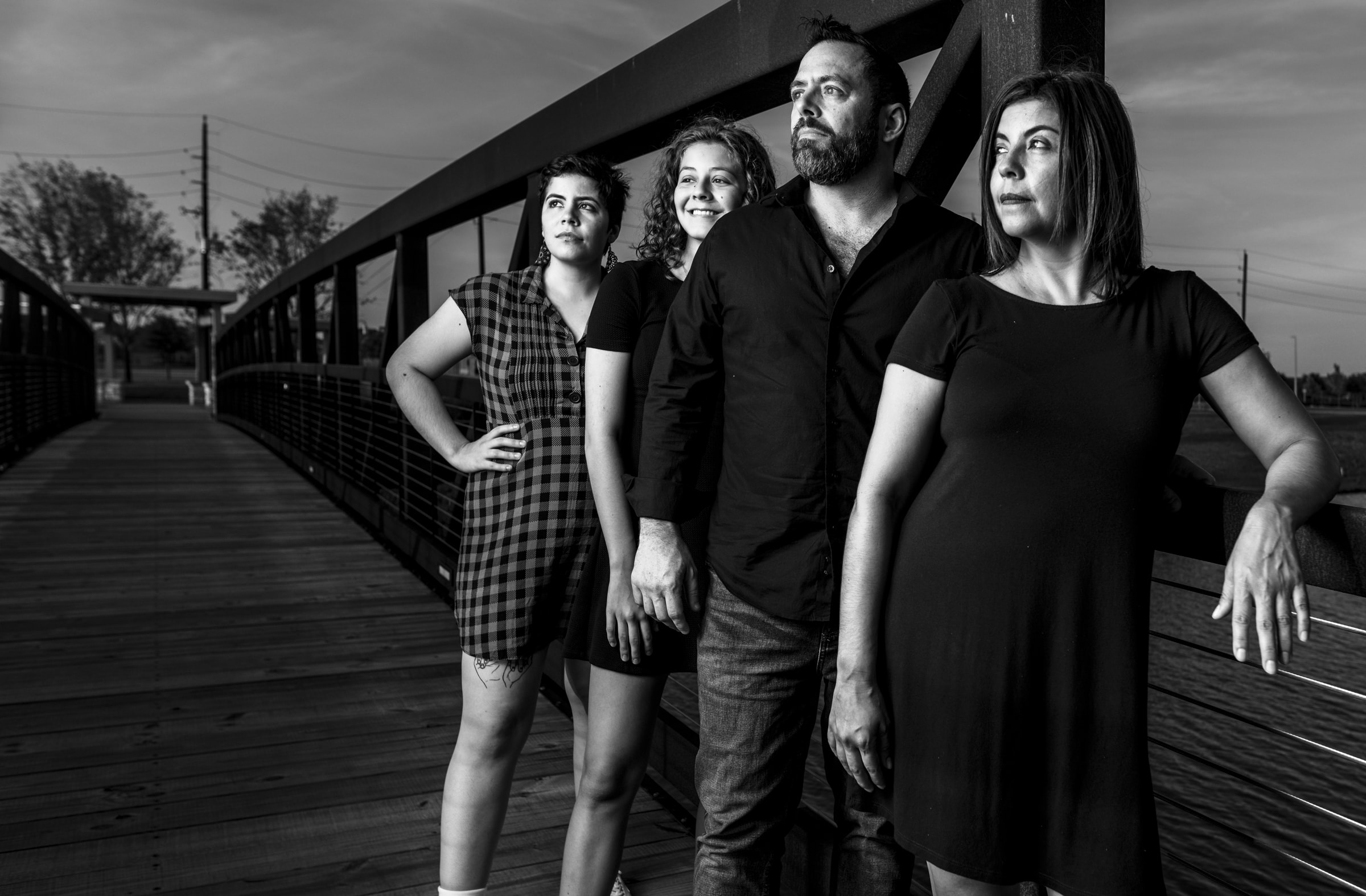 black and white high contrast photo of family on a bridge