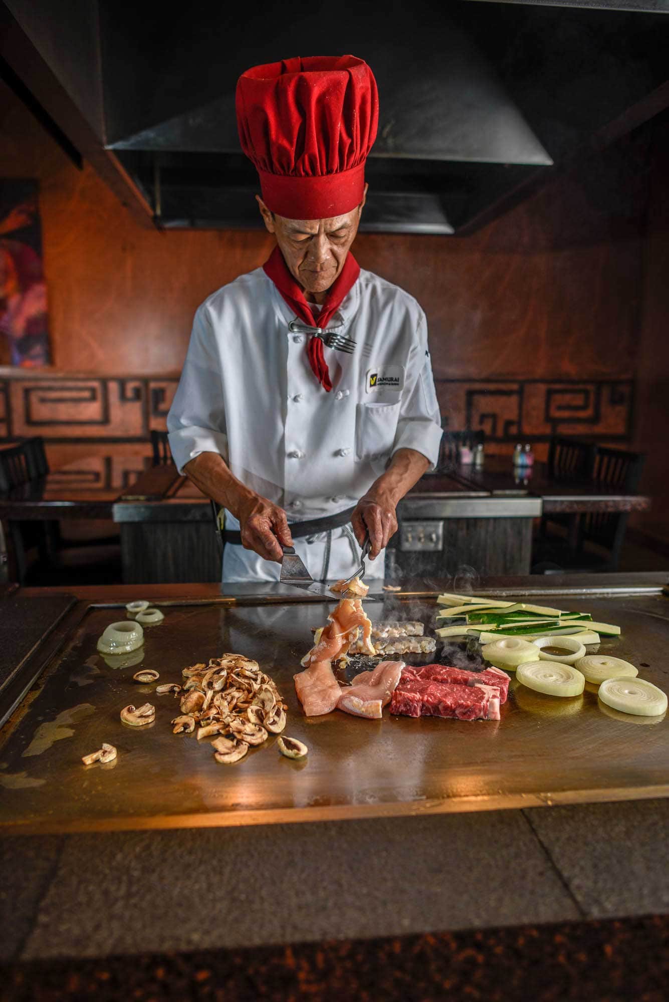 sushi hibachi chef prepares dinner in restaurant over grille