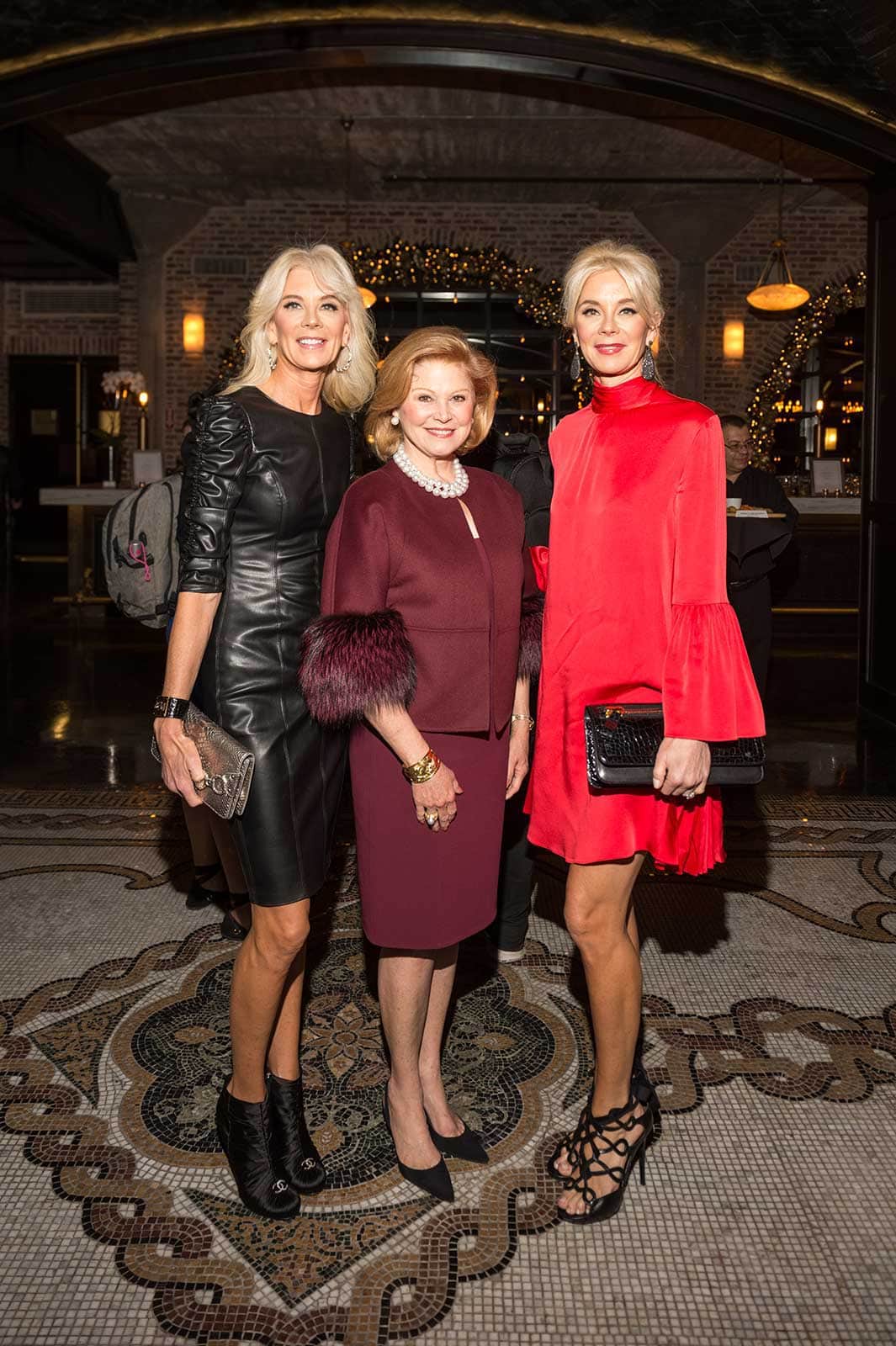 Three women posing for a picture at an event.