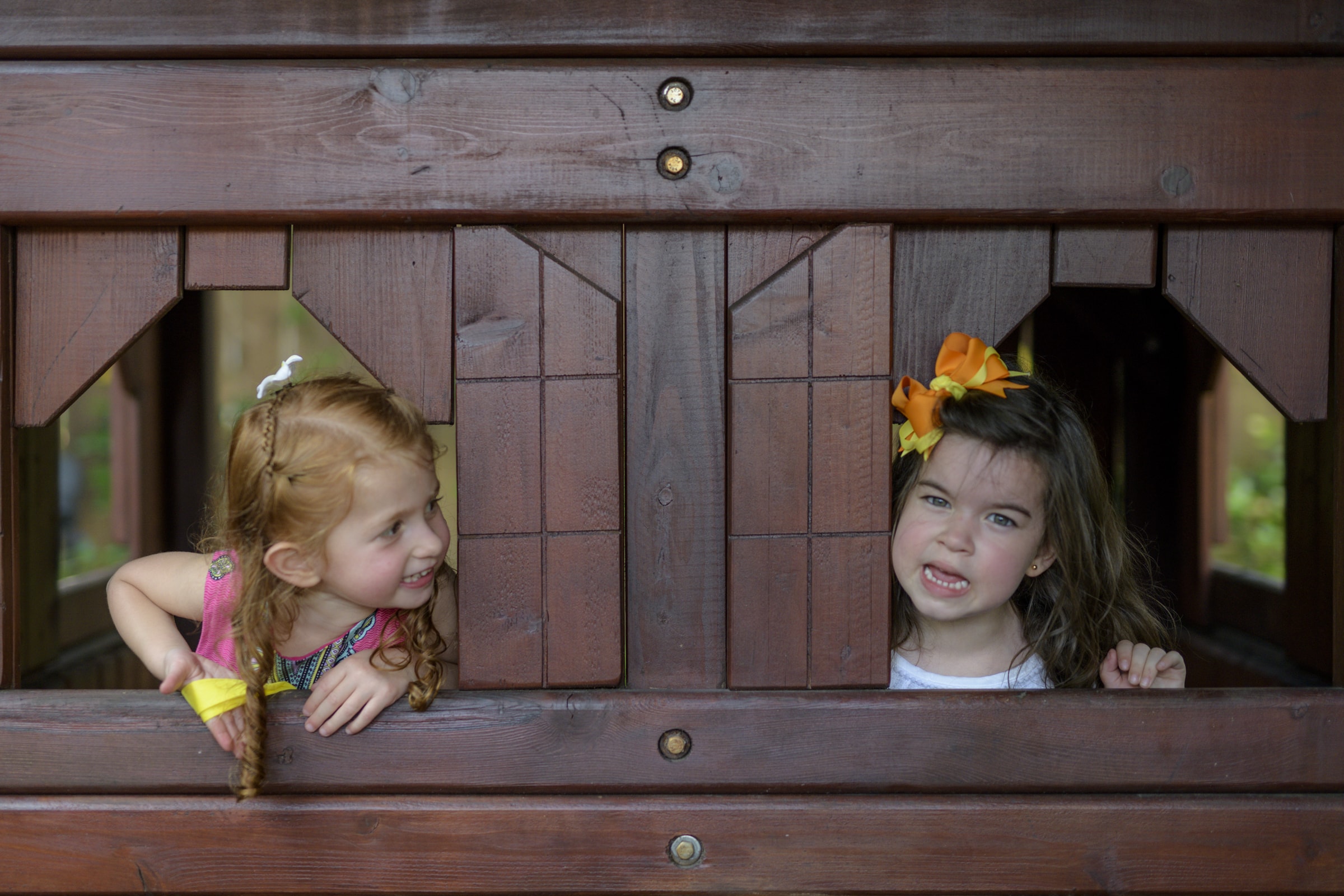 Two children at a birthday party look out their windows at eachother