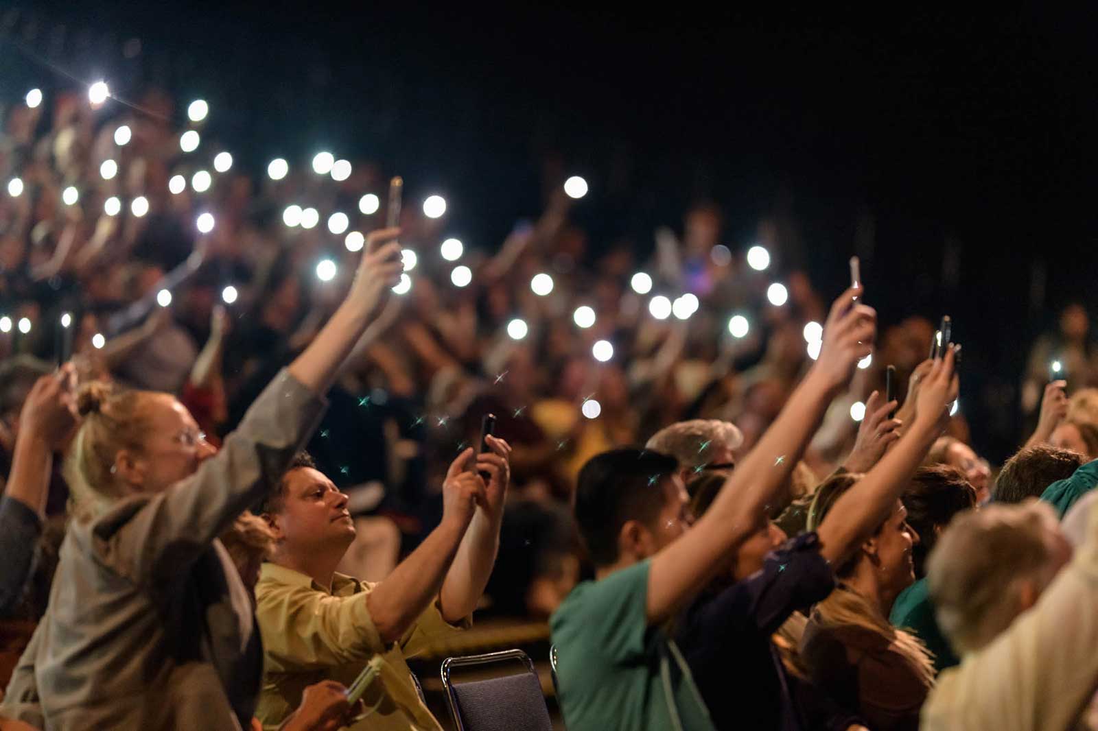 Photographing the Moth Speaking event crowd holds up cellphones