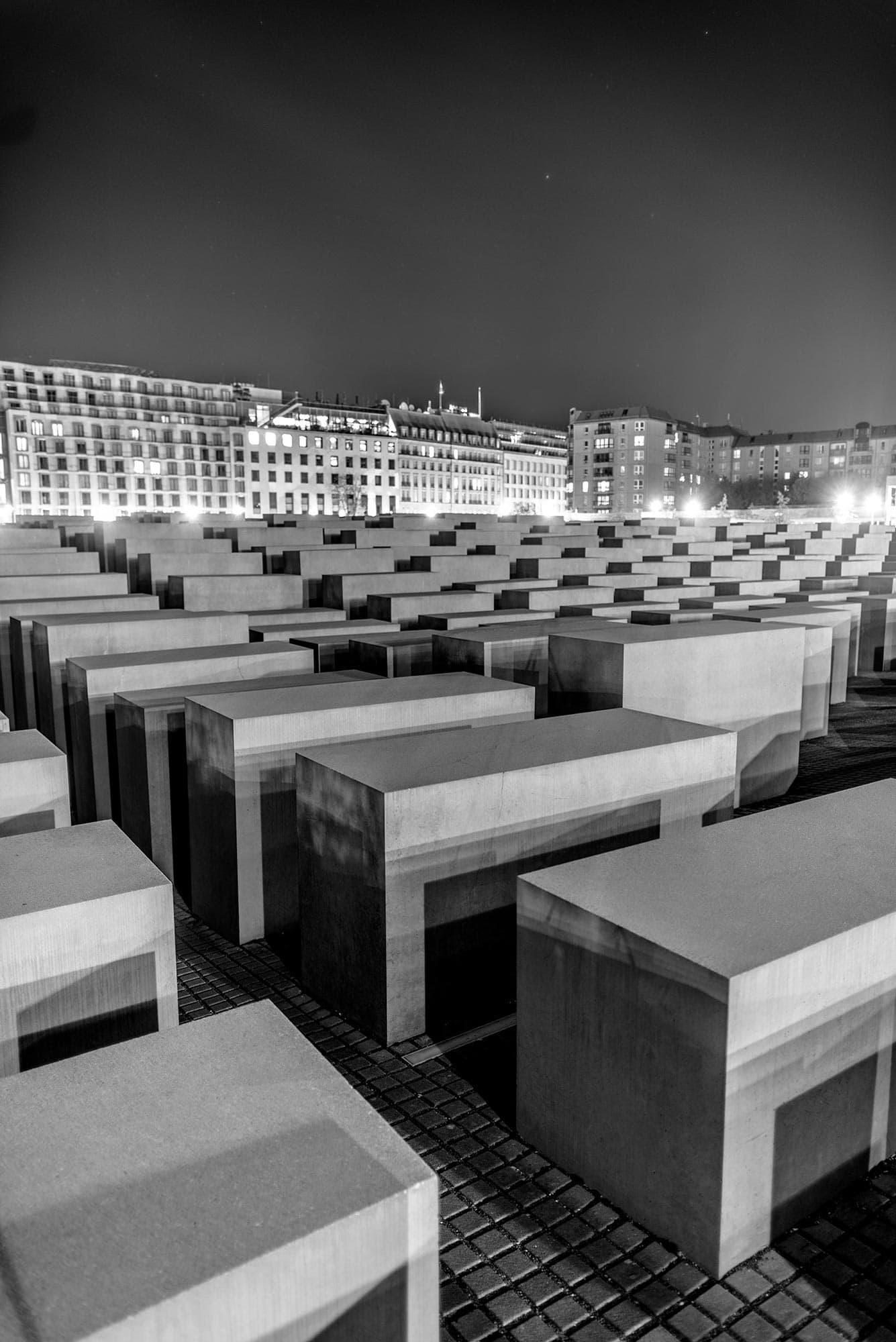 A black and white photo of a cemetery at night.