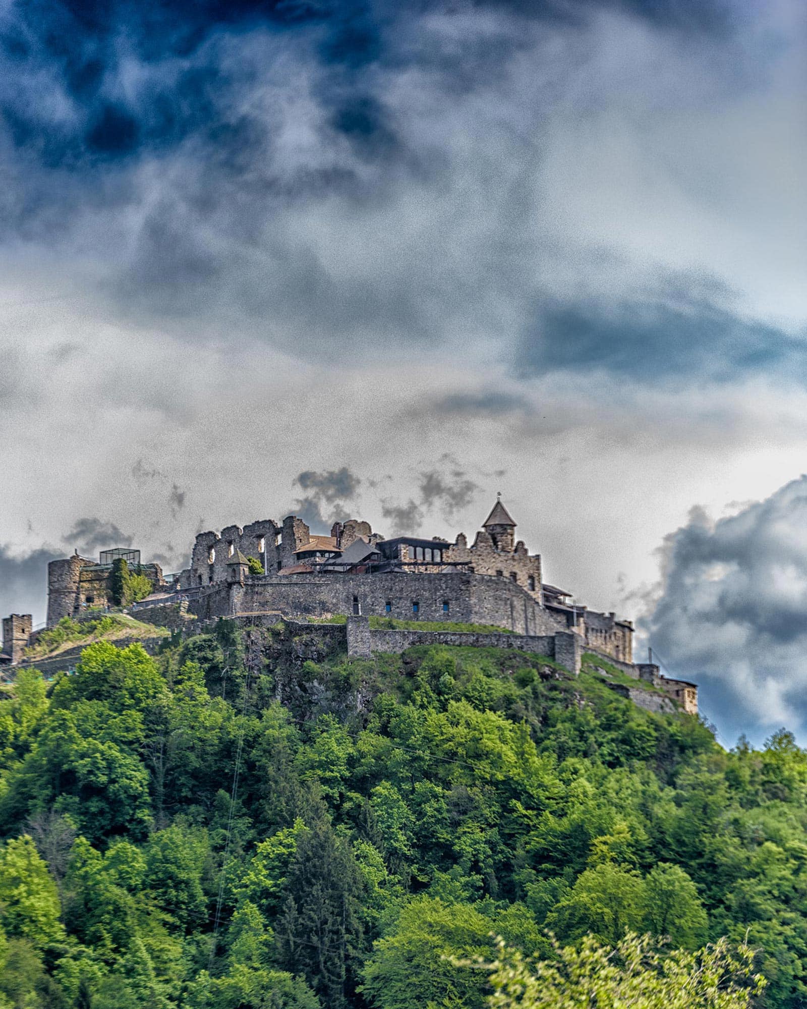 A castle sits on top of a green hill.