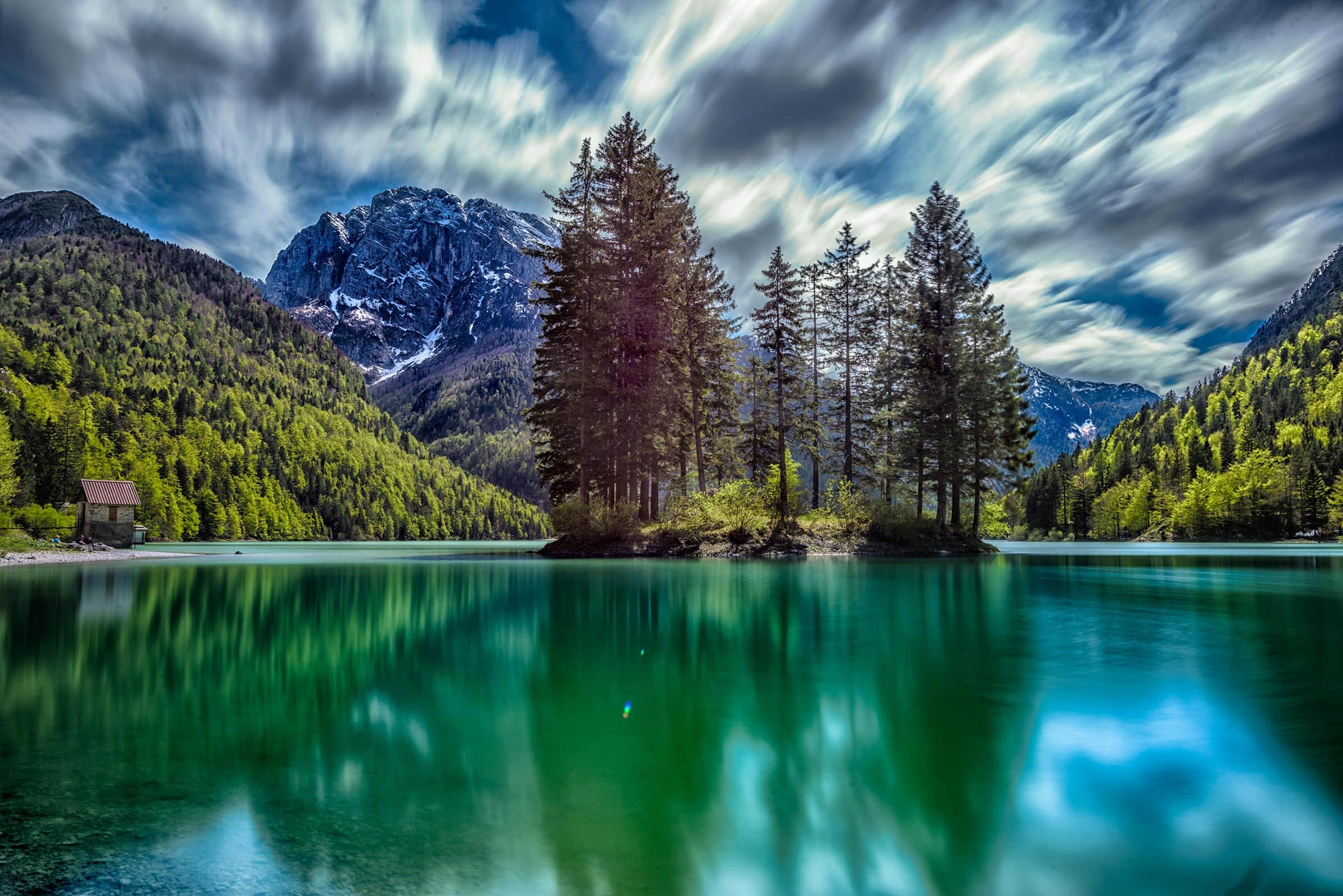 A lake with trees and clouds in the background.