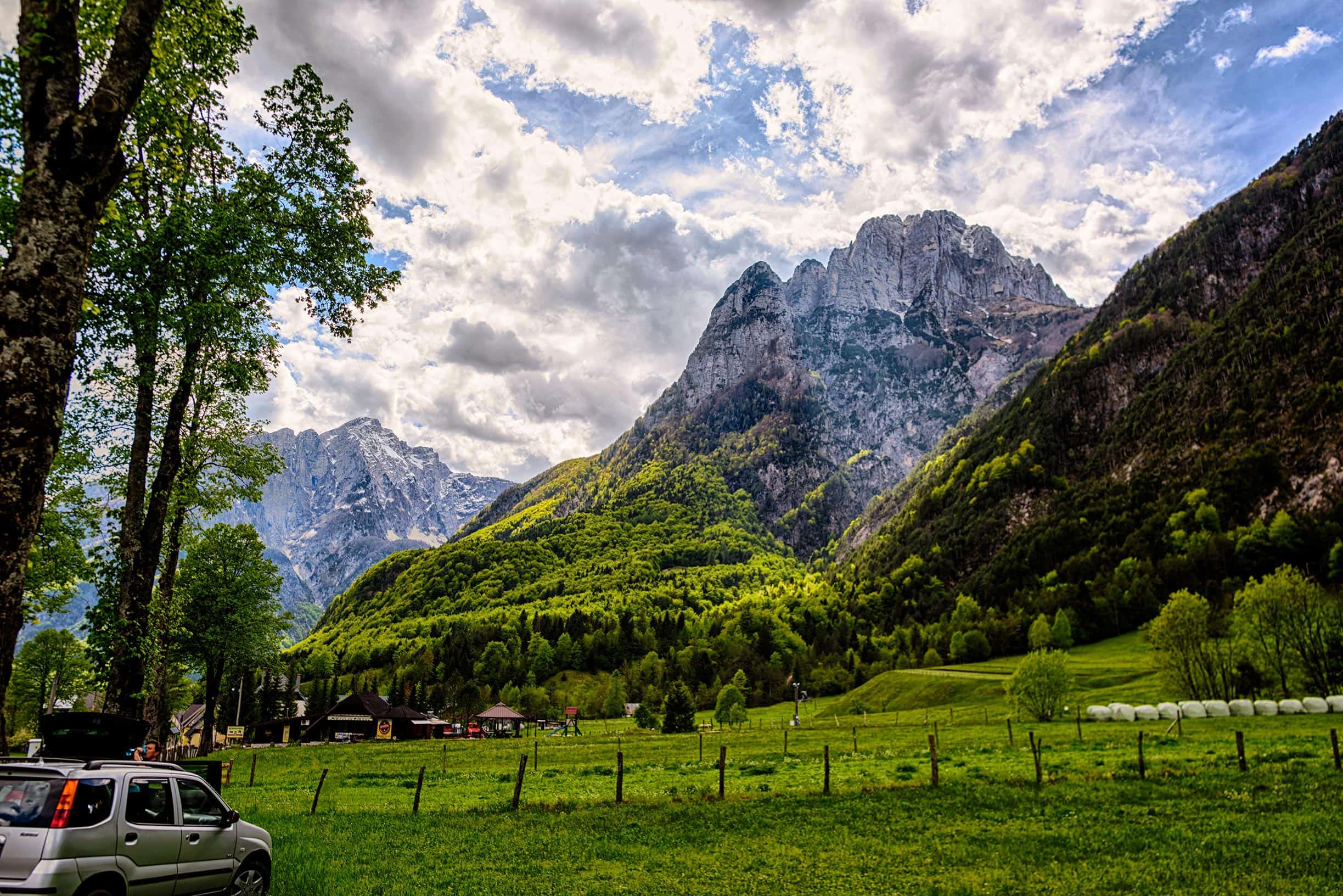 A car parked in a field next to a mountain.