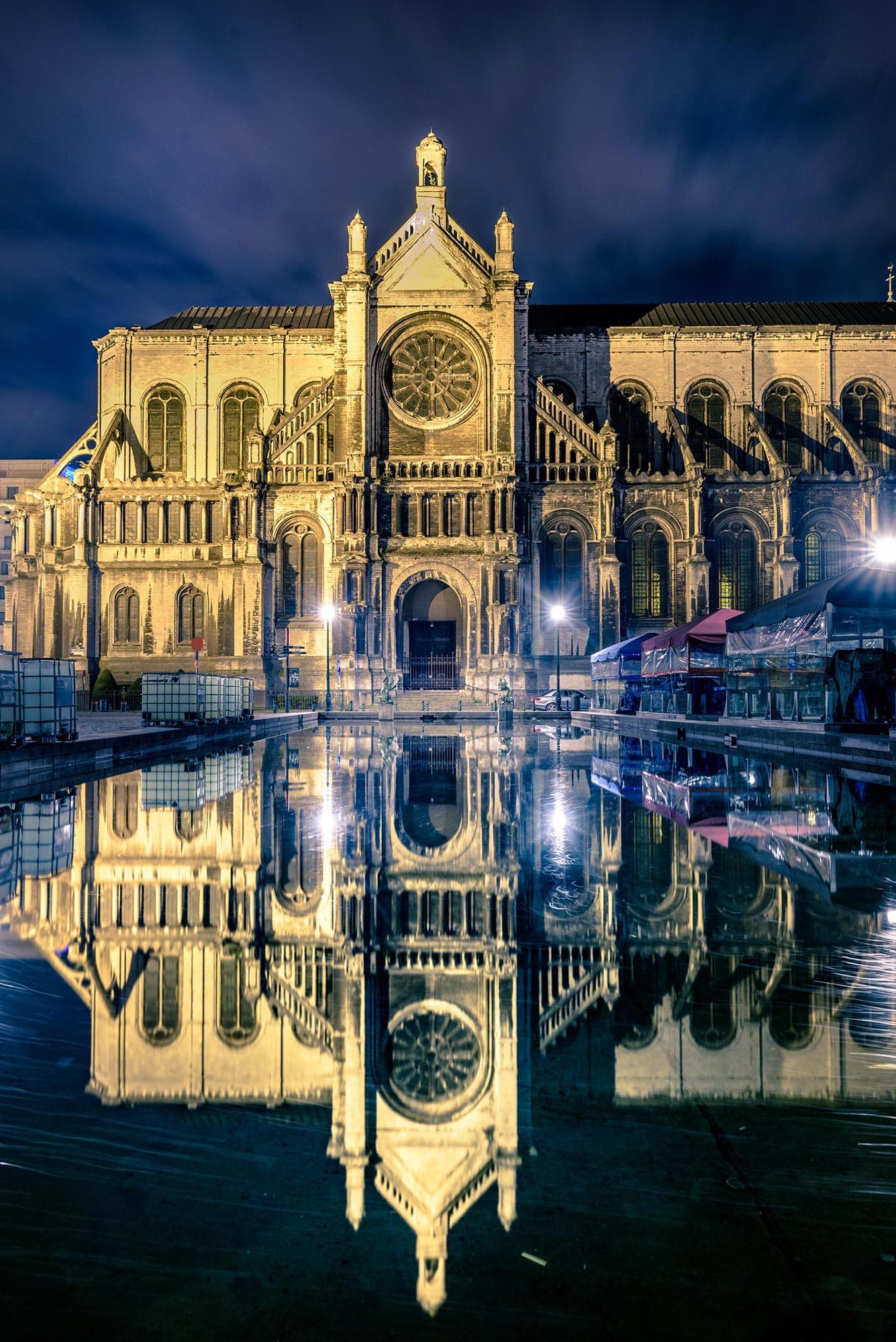 A cathedral is reflected in a pond at night.