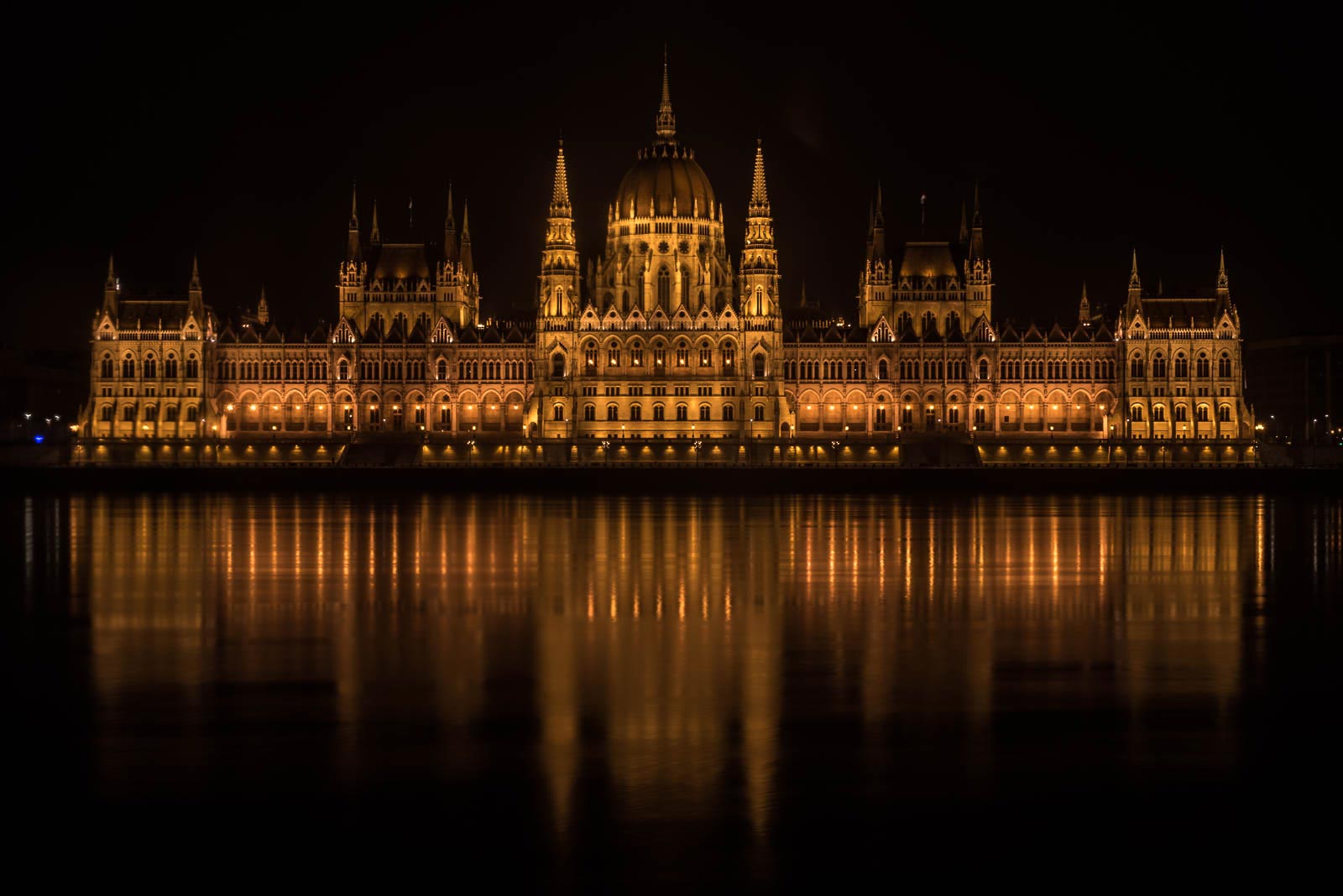 The hungarian parliament building is lit up at night.