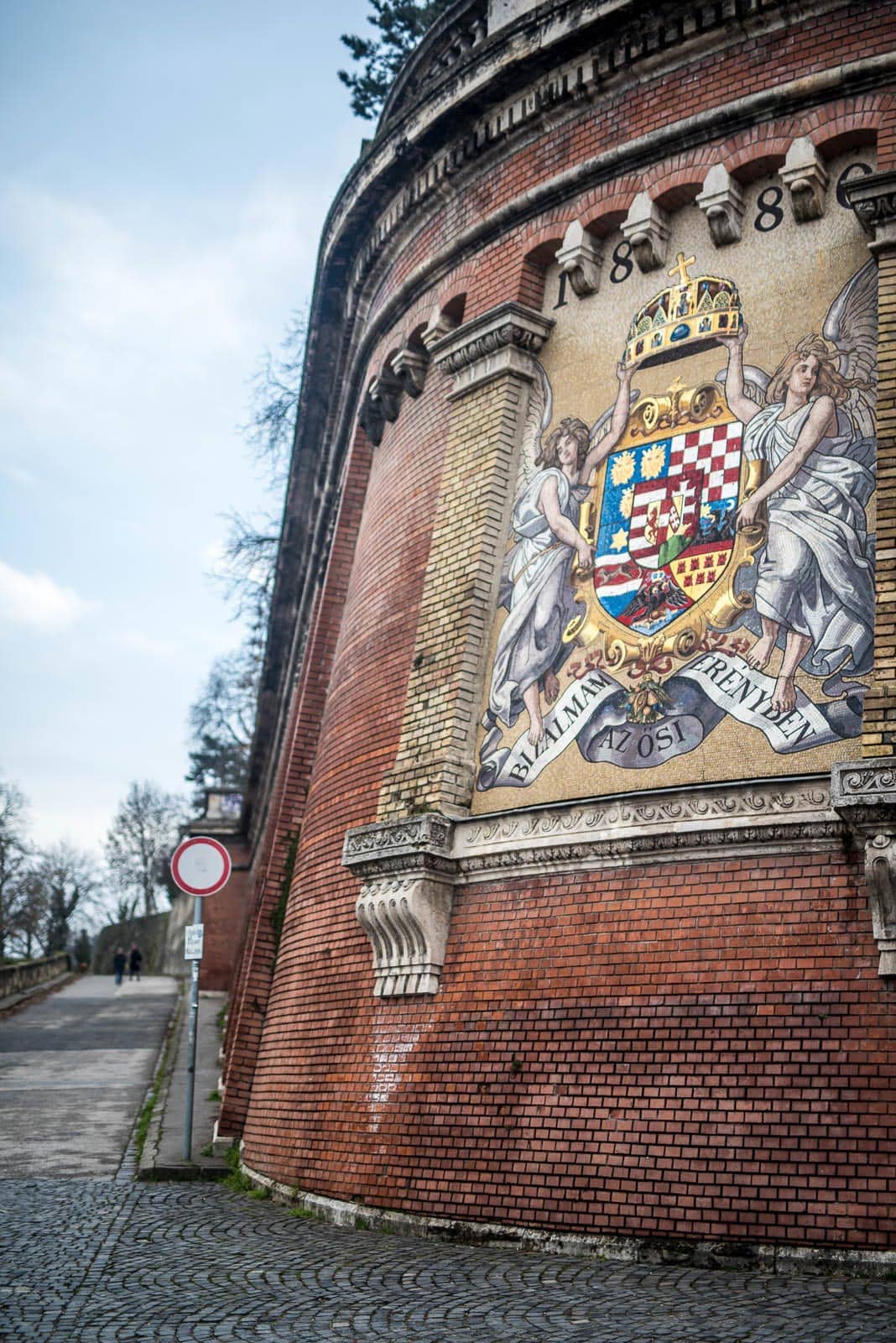 A brick wall with a coat of arms on it.