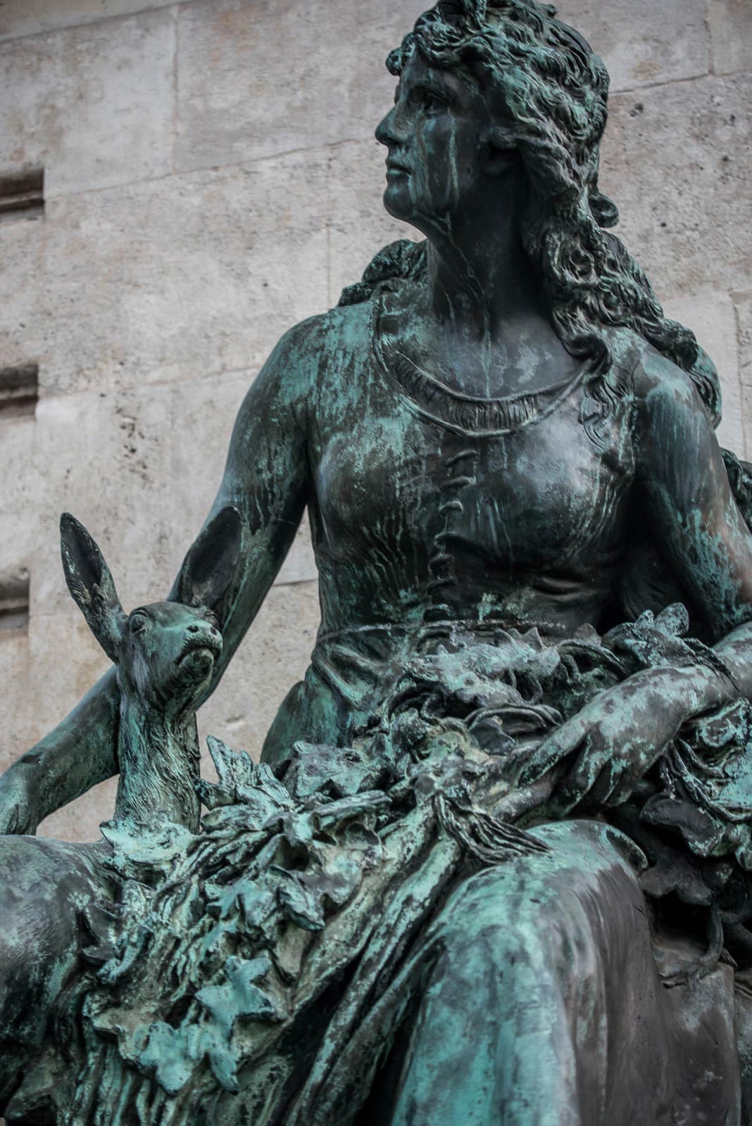 A statue of a woman sitting on a bench.