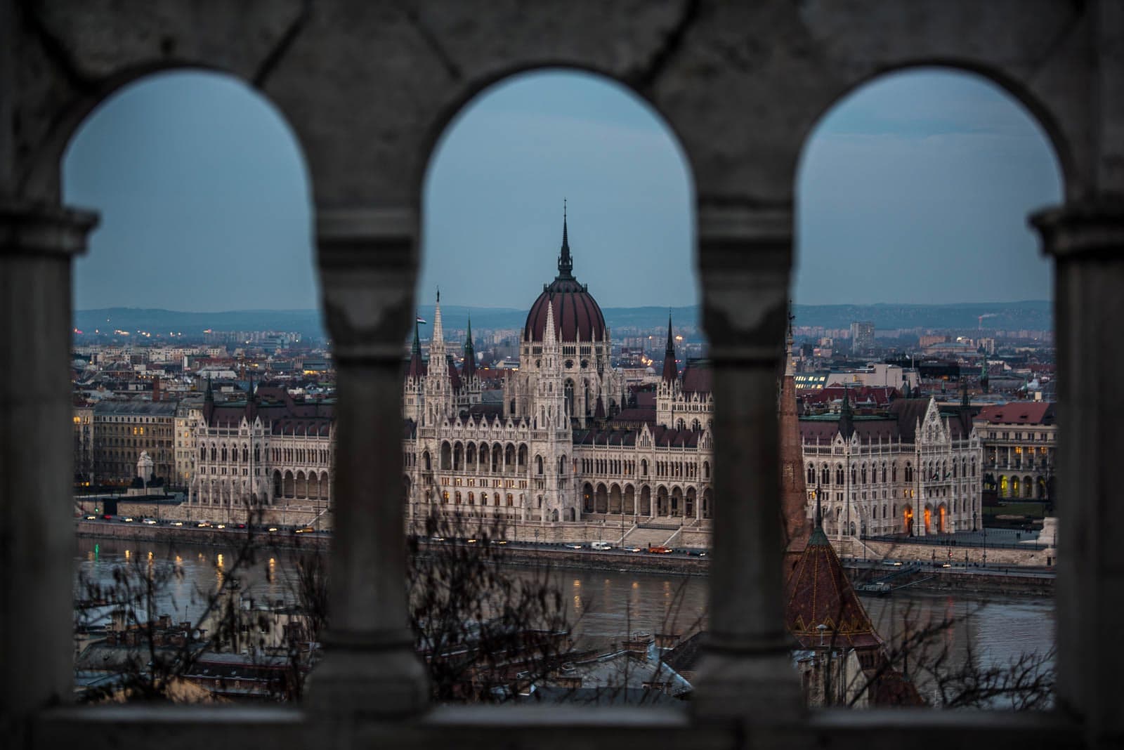 A view of the hungarian parliament building from an arched window.