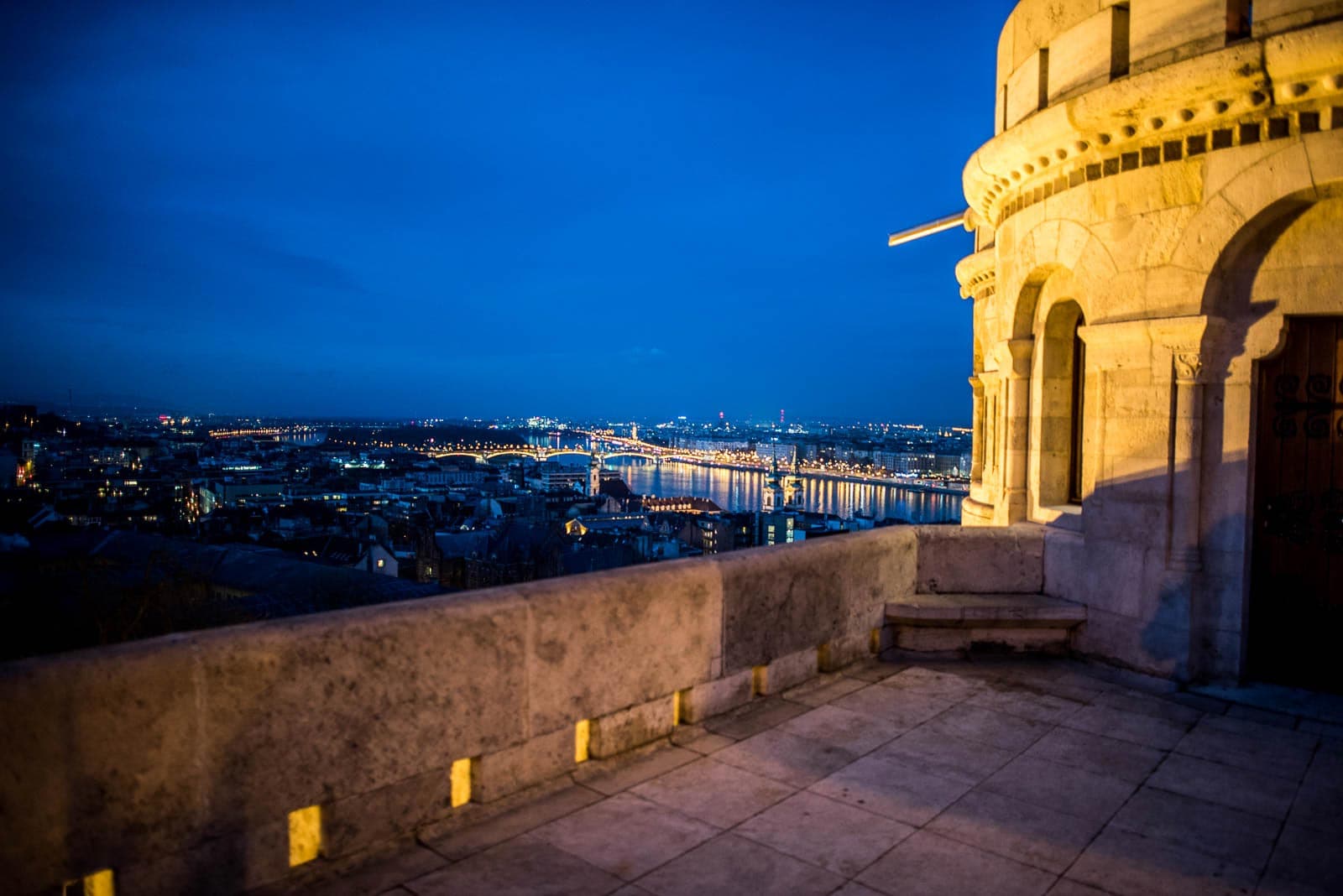 A view of the city at night from the top of a tower.