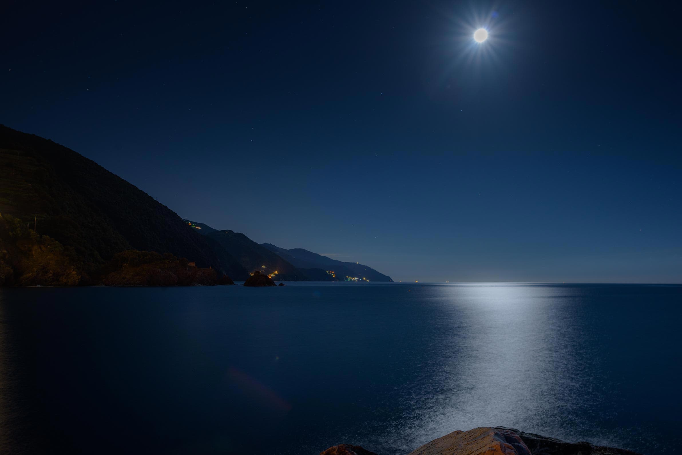 A full moon over a body of water.