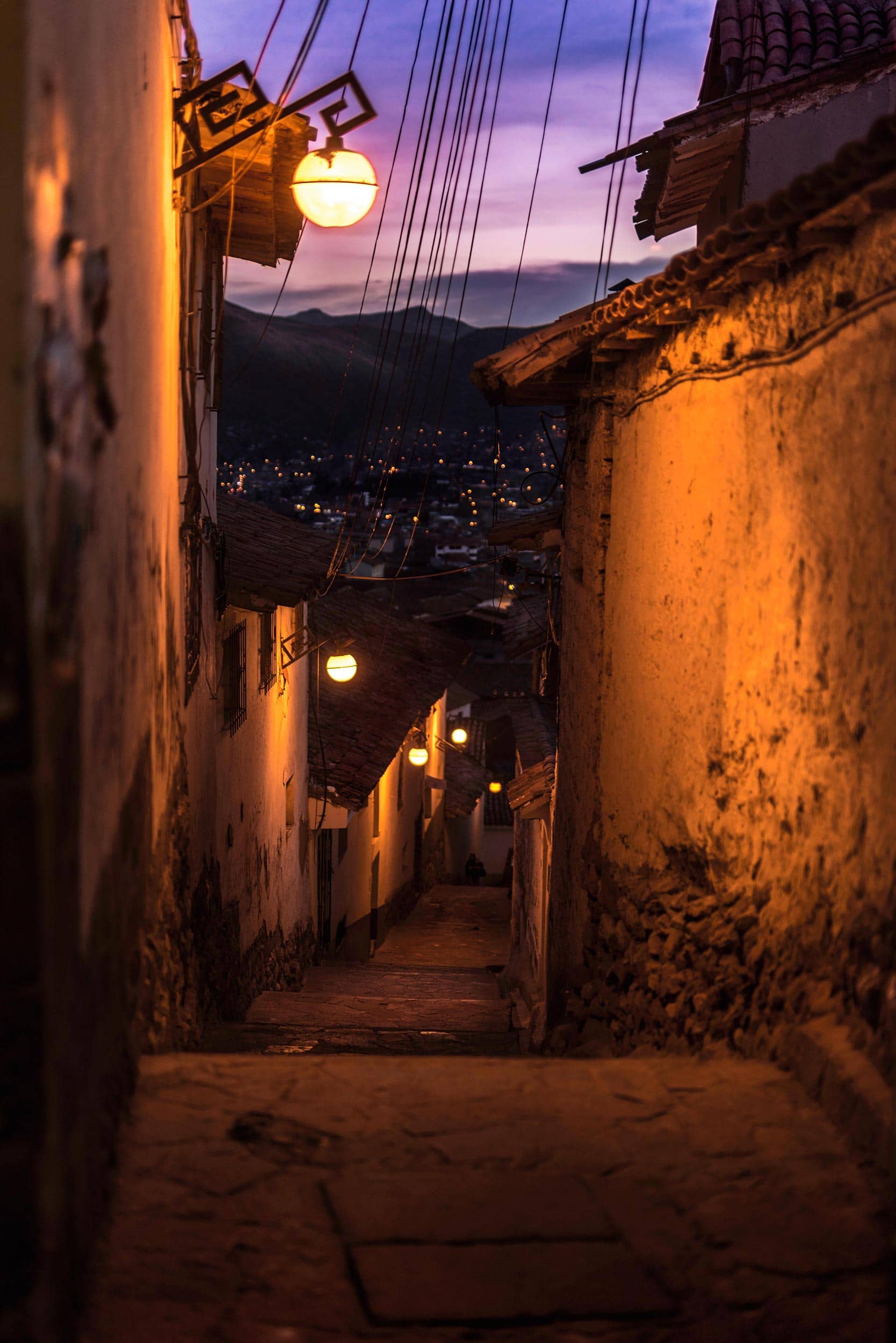 A narrow street in a city at dusk.