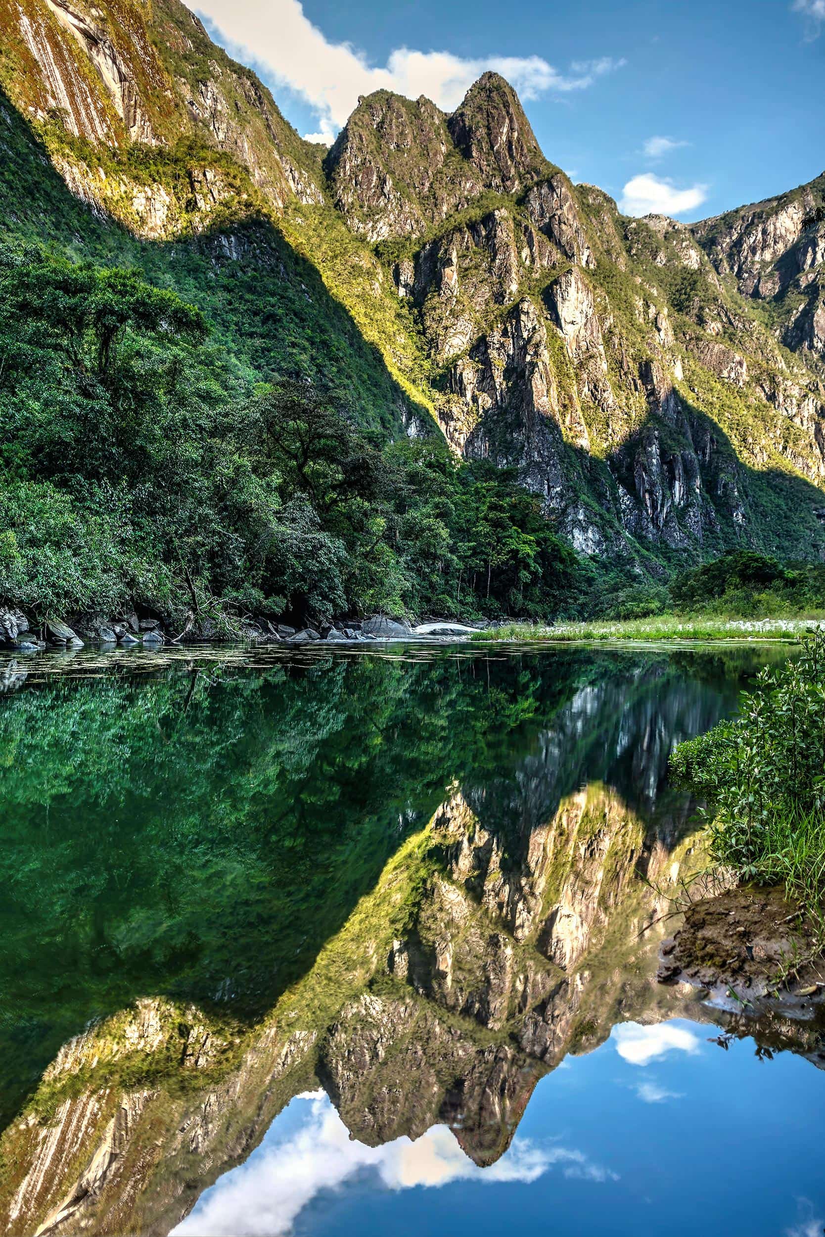 A lake reflects the mountains in the background.