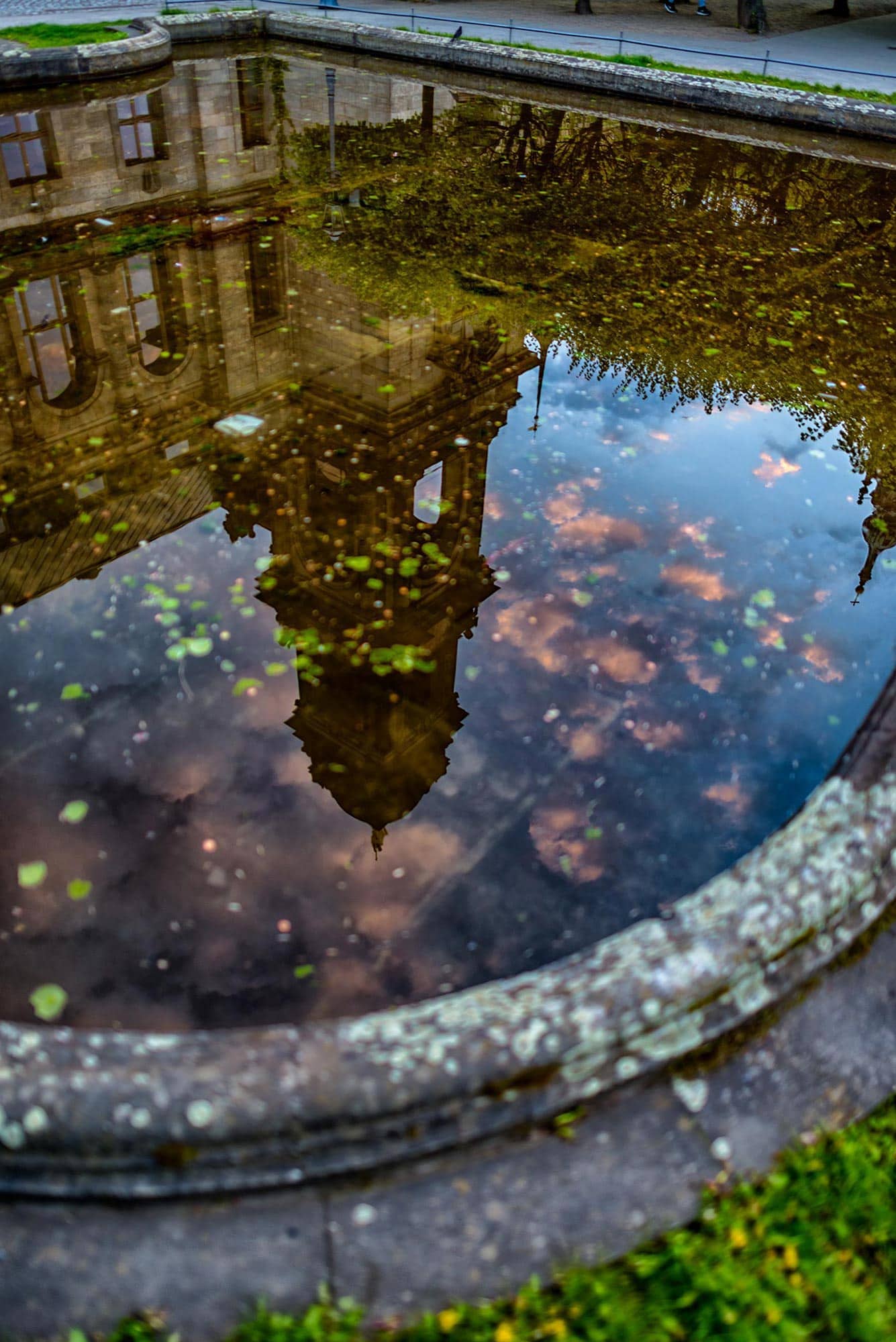 A pond with a building reflected in it.