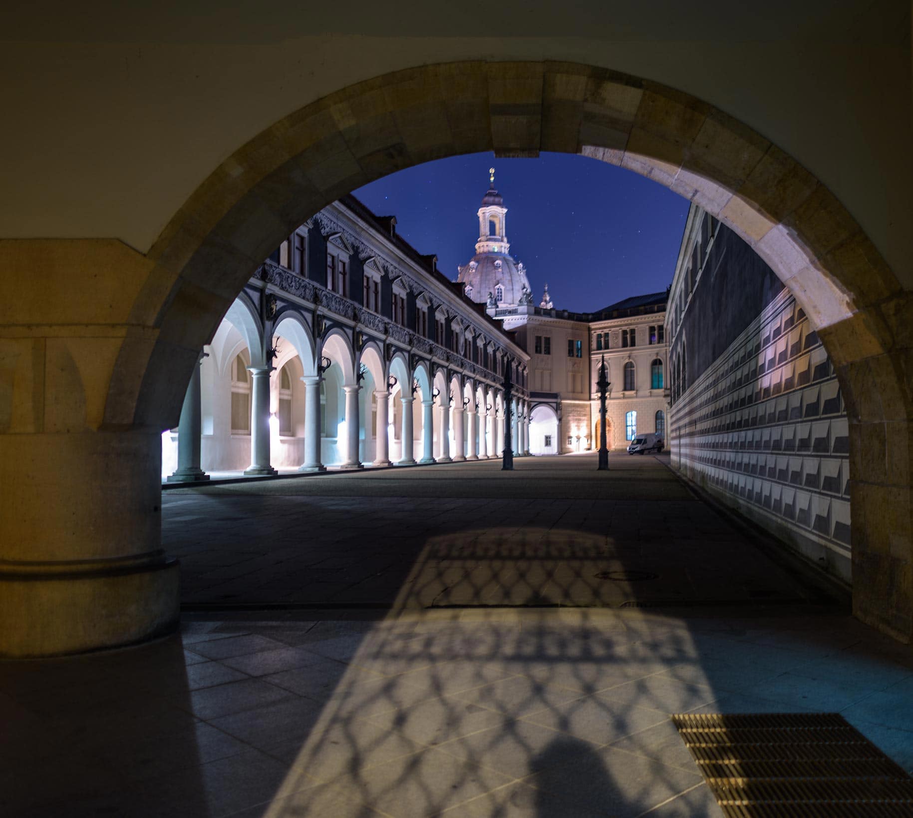 An archway with a building in the background.