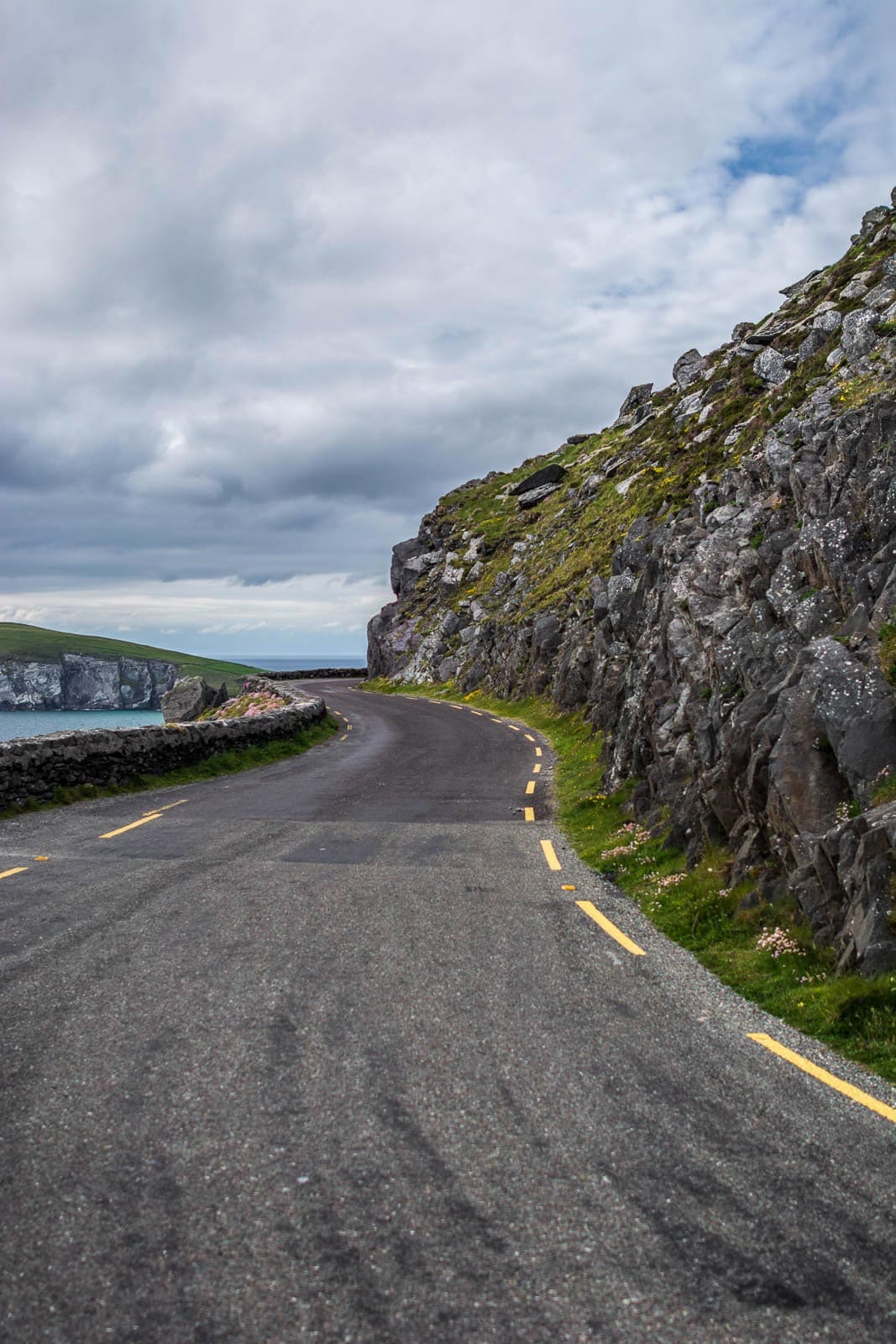 A road leading up to a cliff with a view of the ocean.