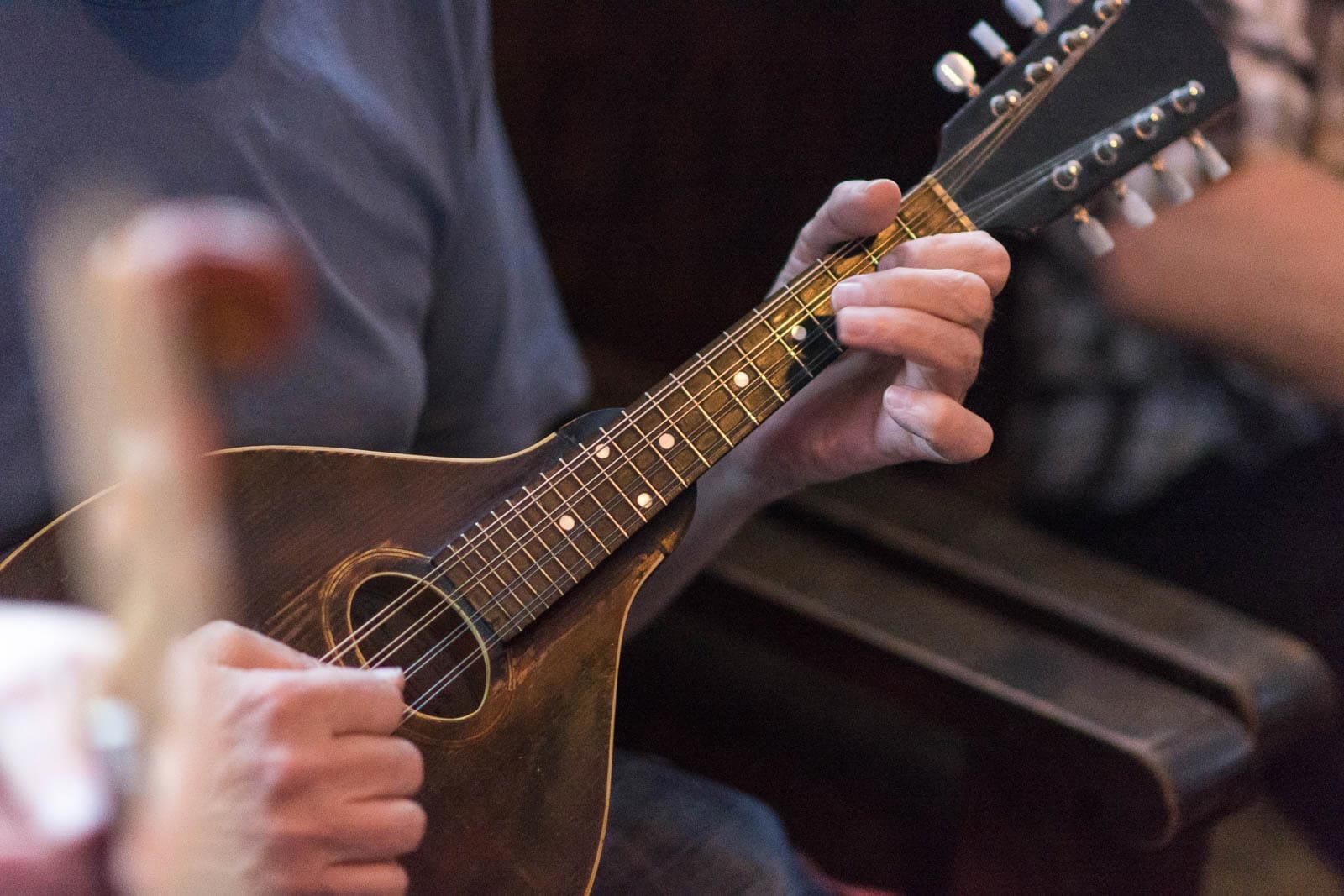 A man playing a mandolin in a pub.