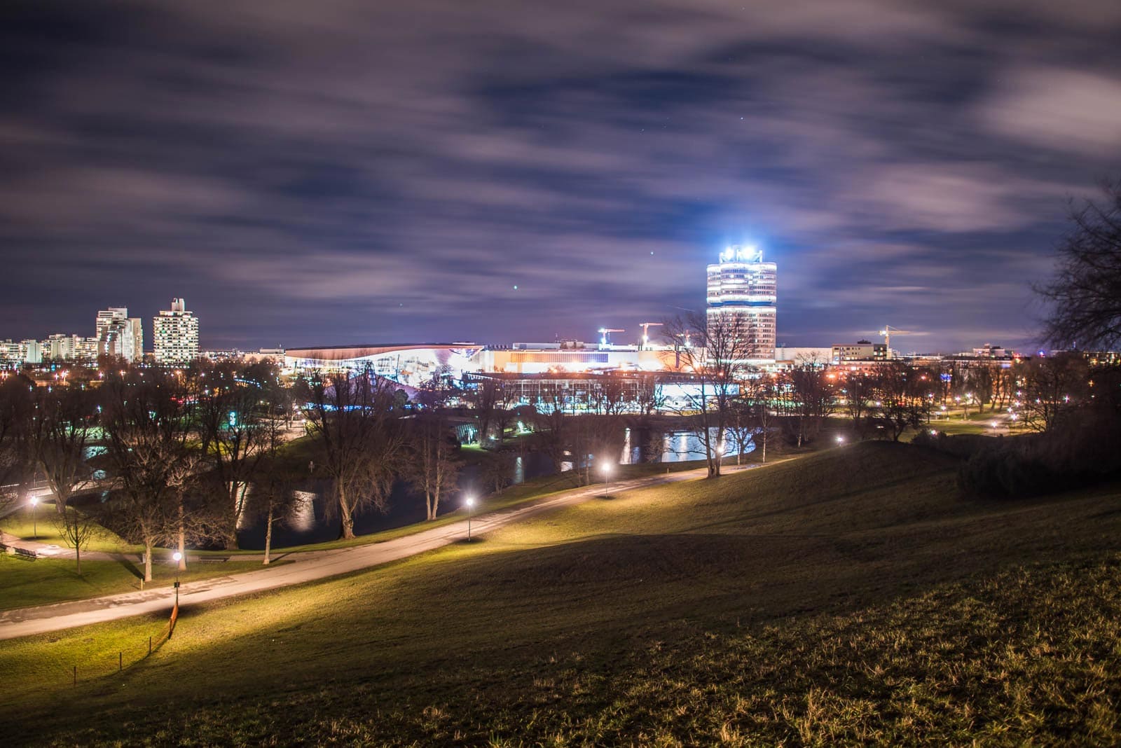 A view of a city at night with a park in the background.