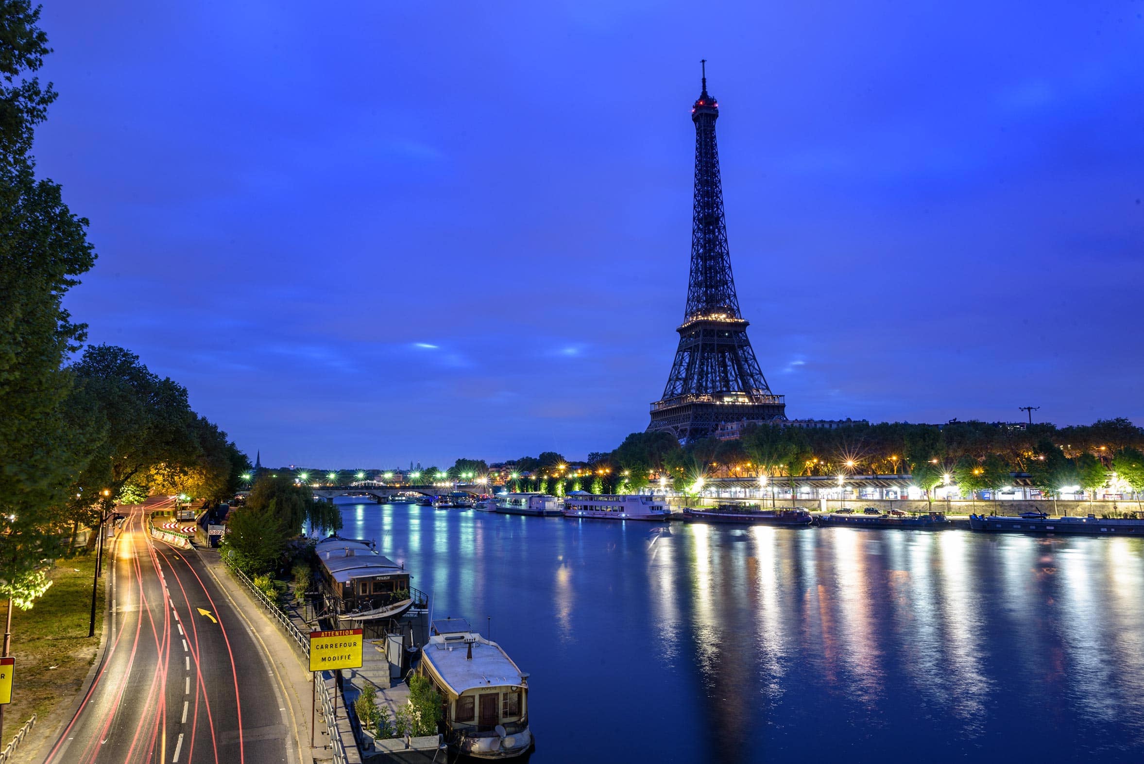 The eiffel tower and the seine river at night.