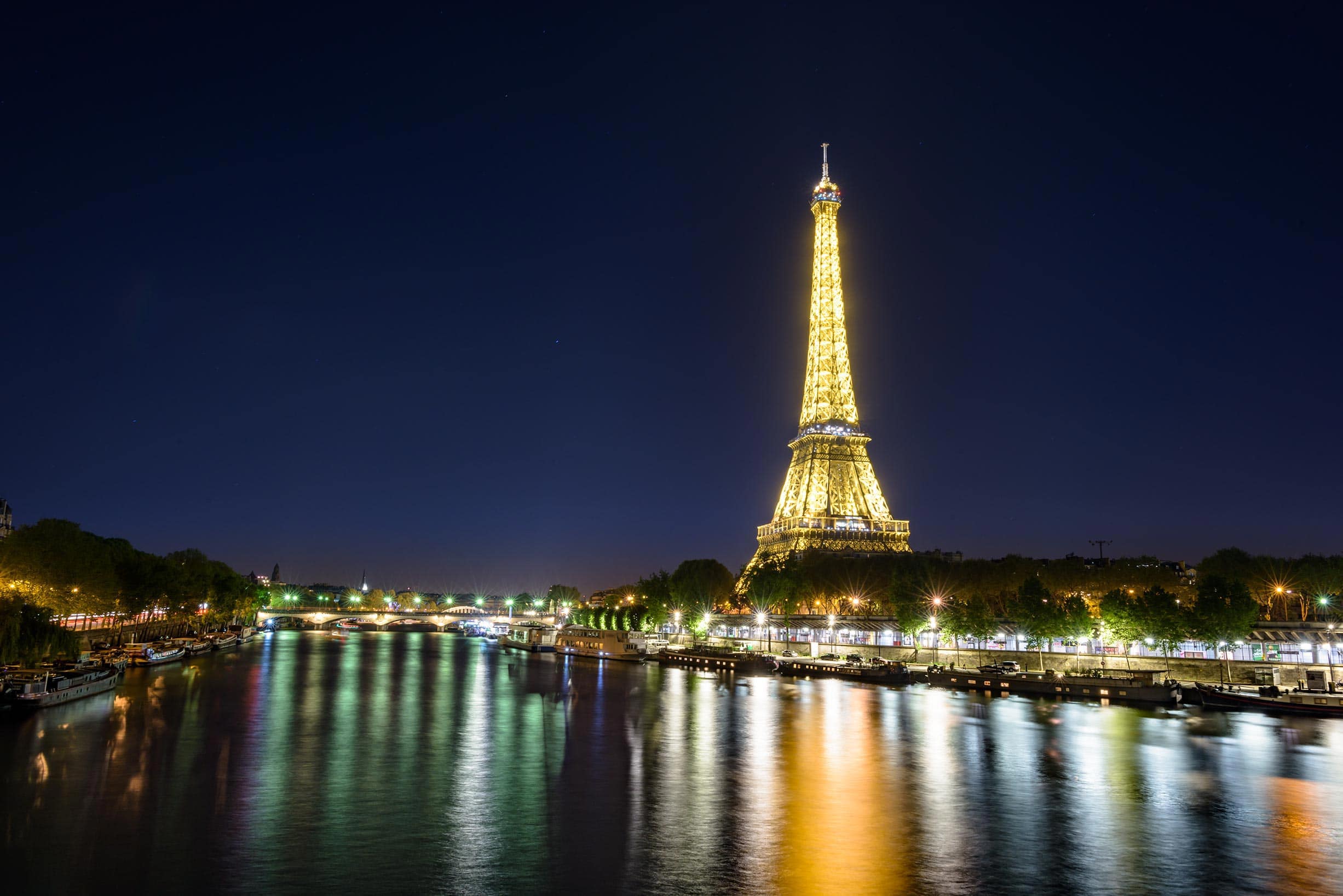 The eiffel tower is lit up at night.