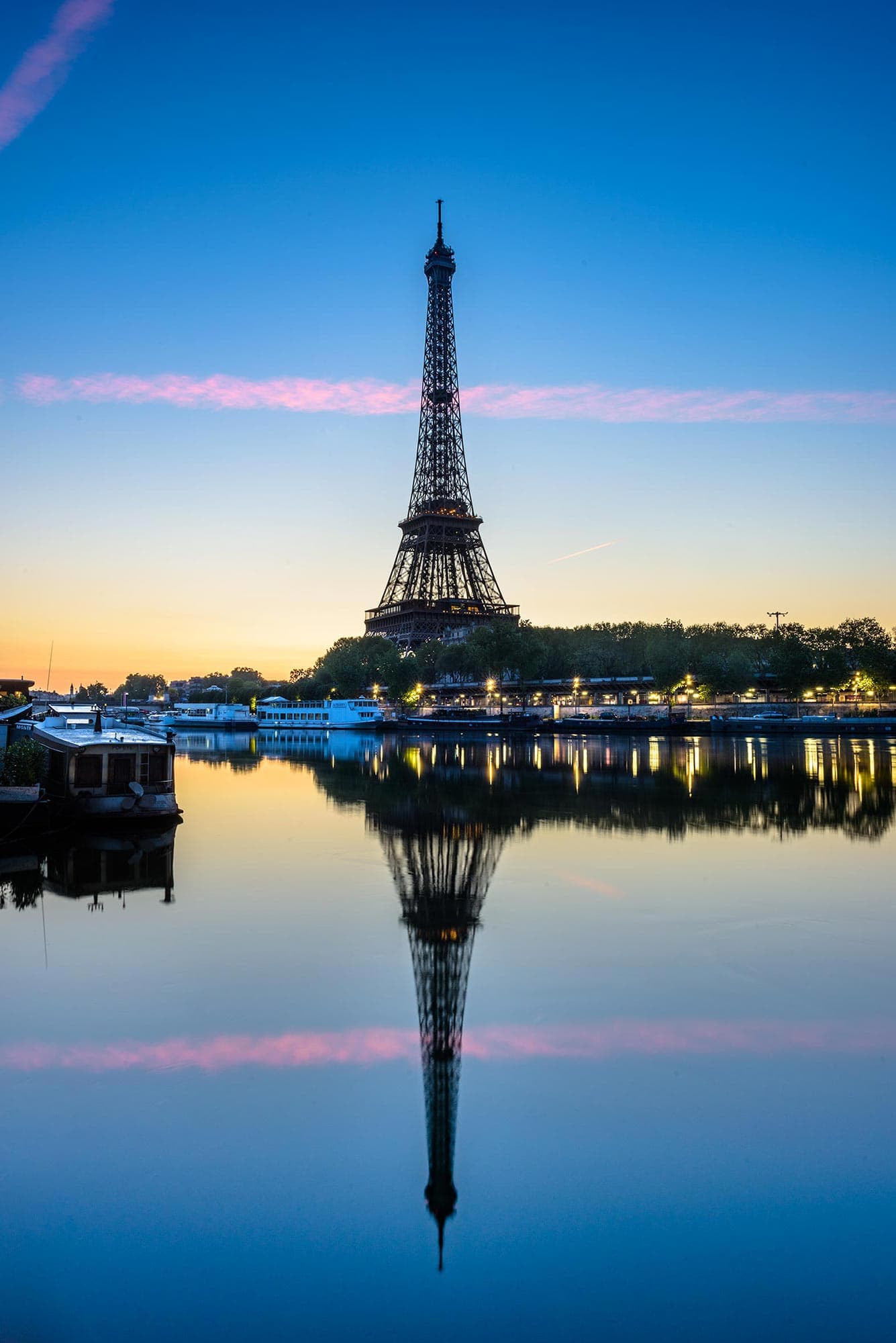 The eiffel tower is reflected in the water.