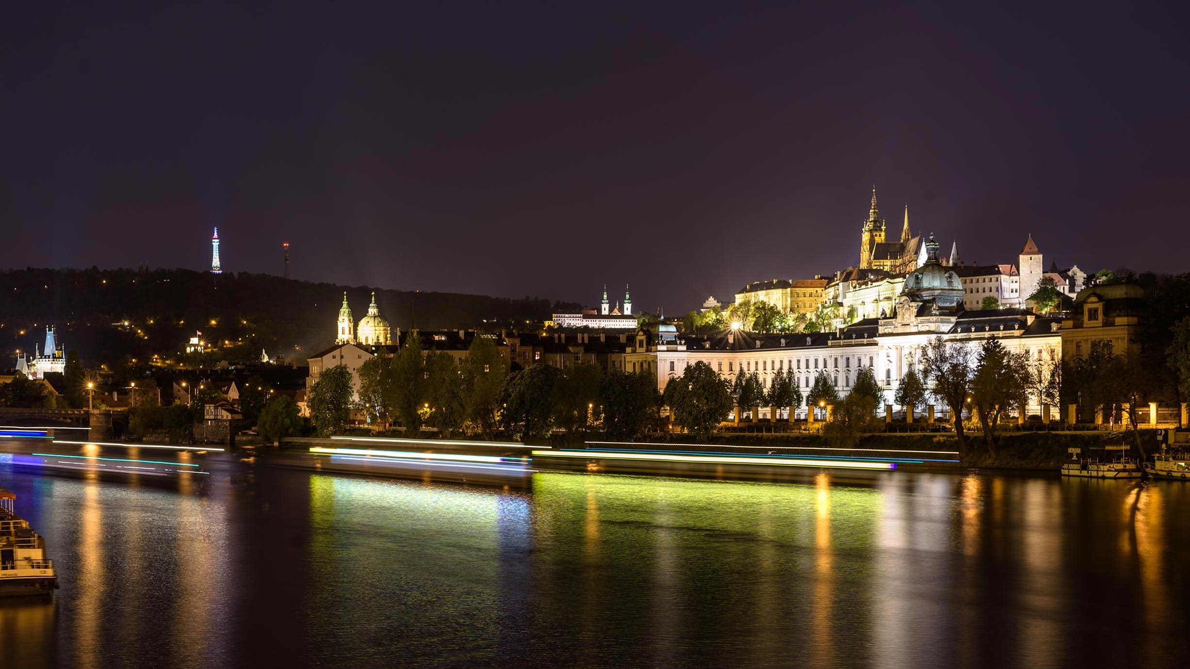 A city at night with a river in the background.