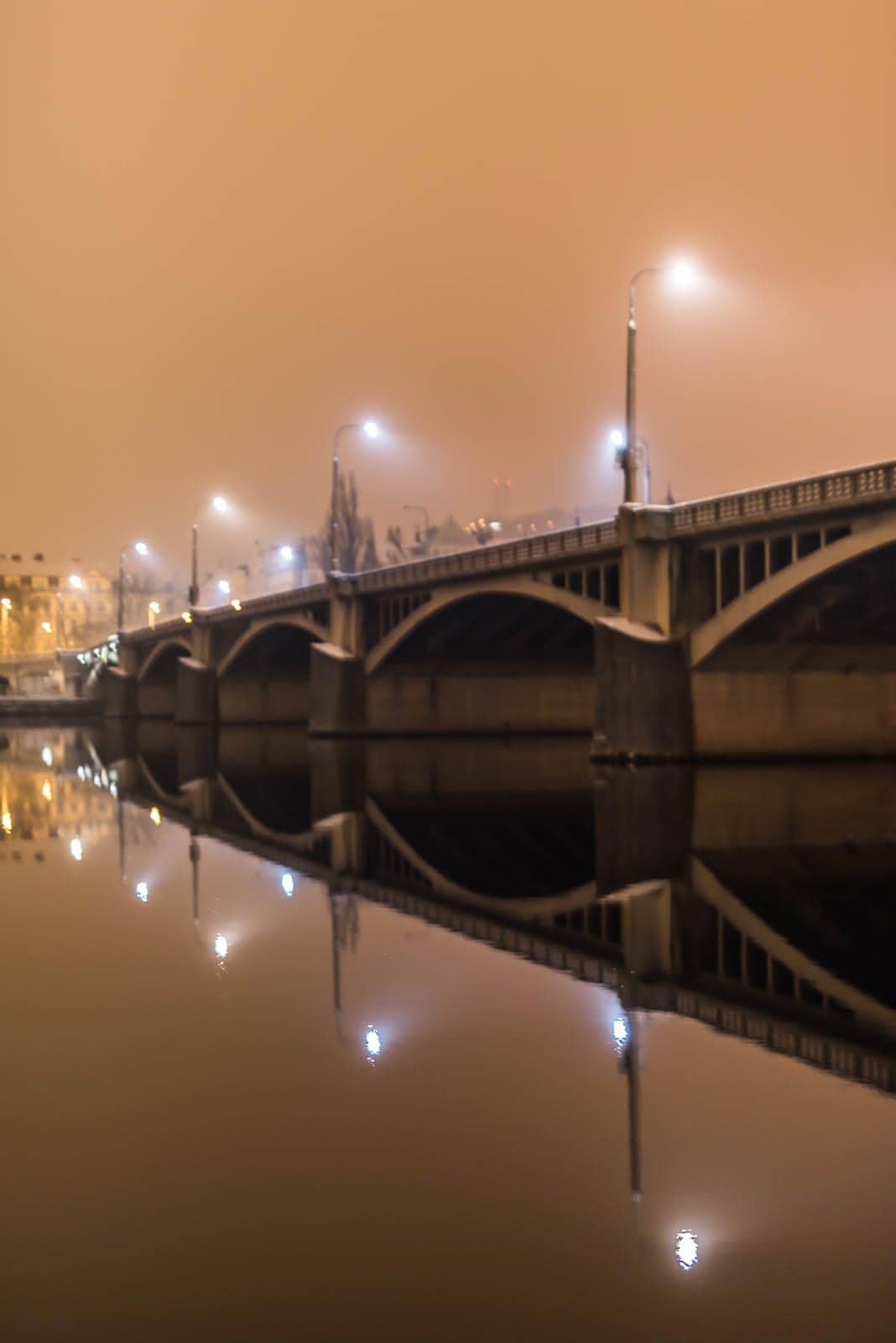 A bridge over a body of water at night.