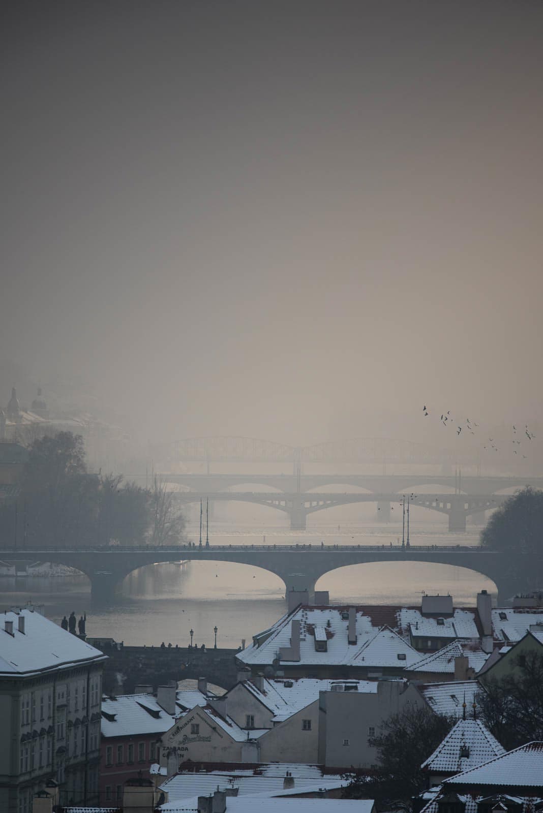 A snowy view of a city with a bridge.