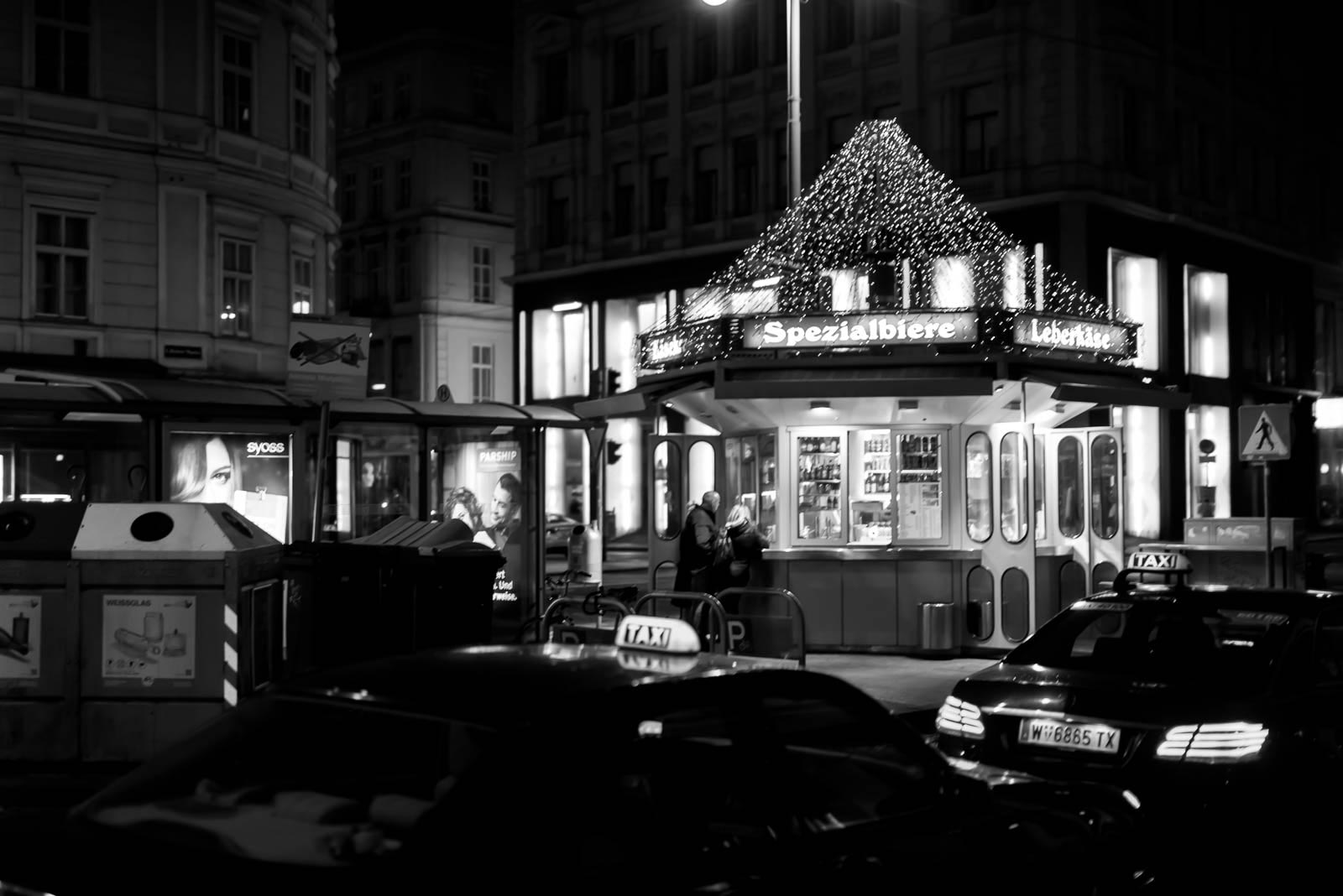 A black and white photo of a street with a christmas tree.