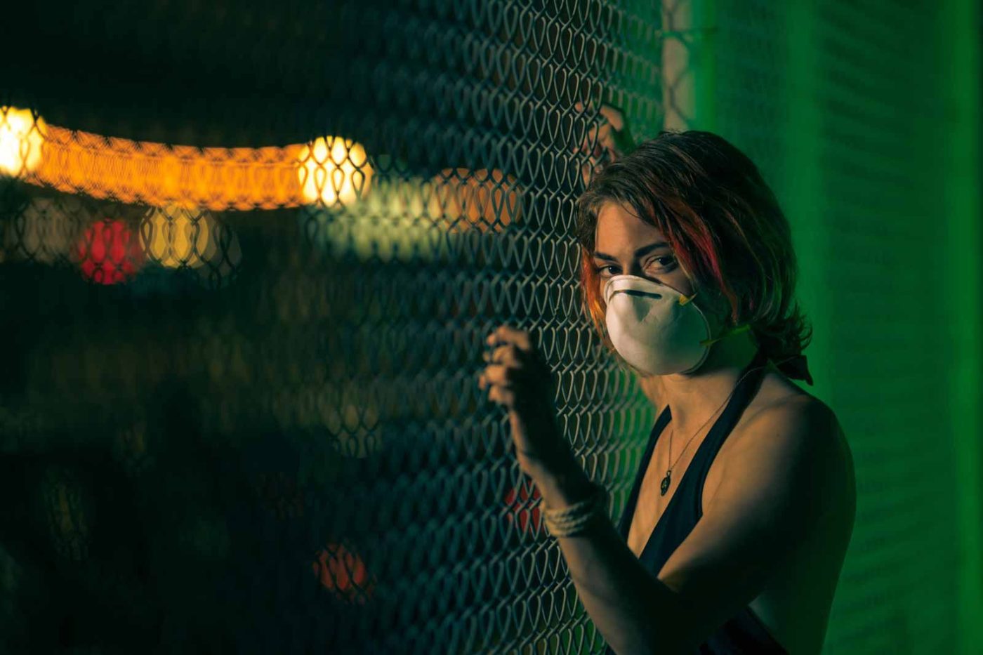 Chris Spicks, a Houston photographer, captures a woman wearing a face mask in front of a fence with his creative photography skills.