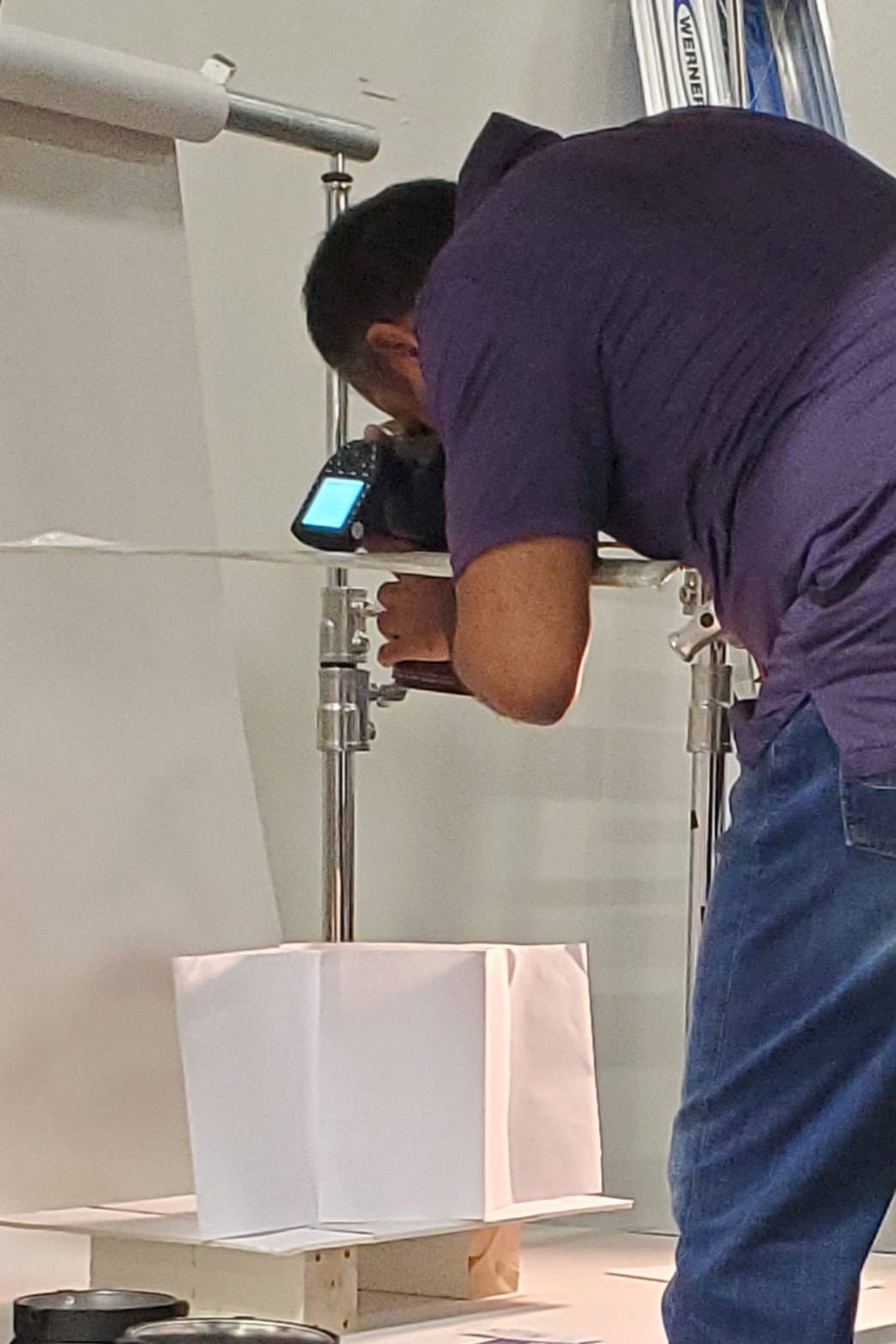 A man working on a white box in a studio.