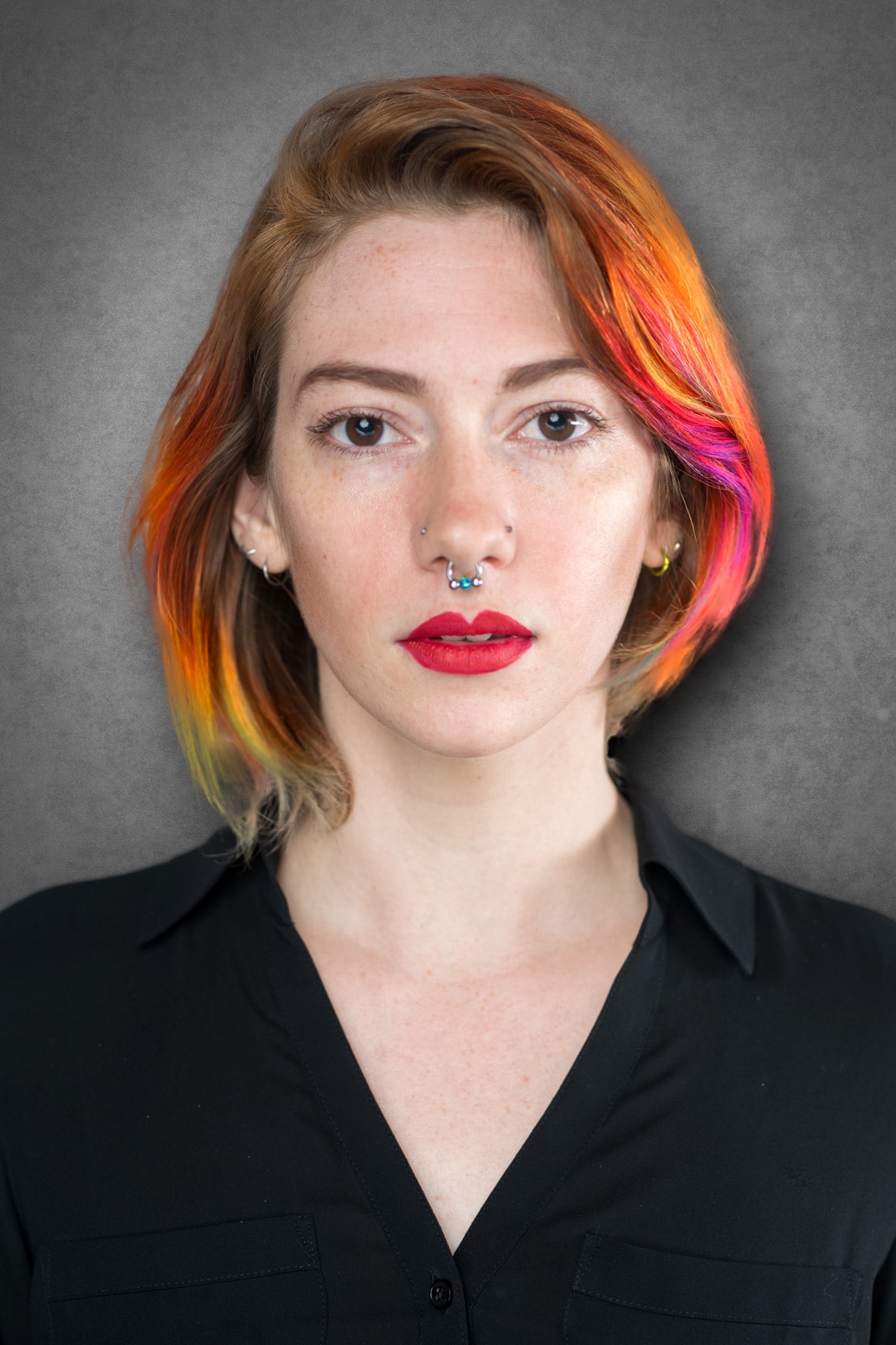 A woman with colorful hair and piercings.