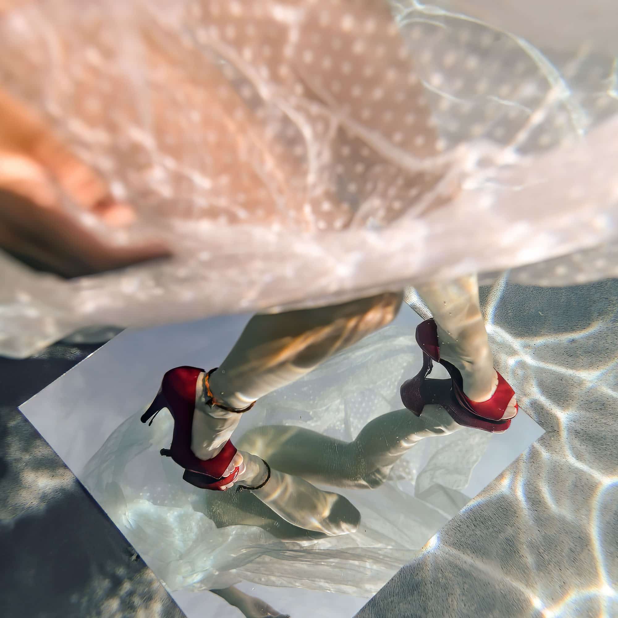 Red shoes standing on a mirror