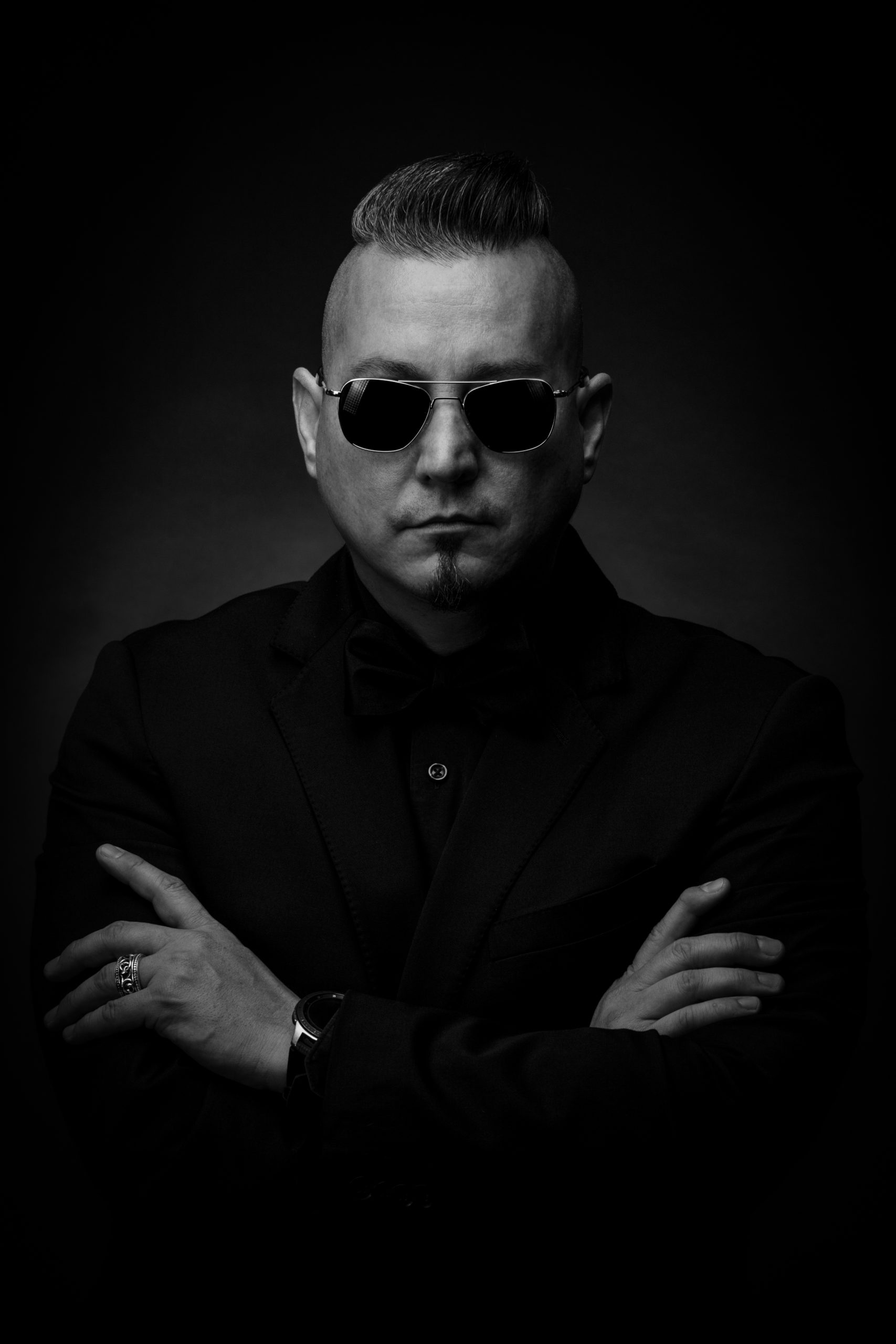A black and white photo of a man in a suit and sunglasses captured by Chris Spicks Photography.