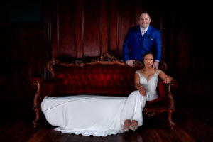 husband and wife pose on couch for bridal photos