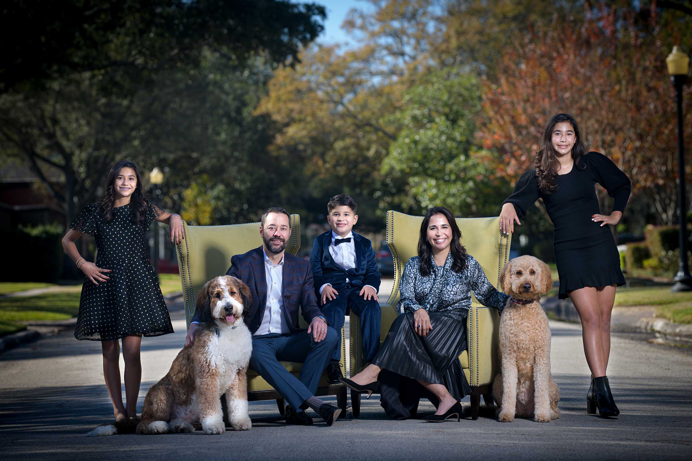 Creative Photography captures a family posing for a photo with their dog in Houston. Chris Spicks Photography showcases this delightful moment on film.