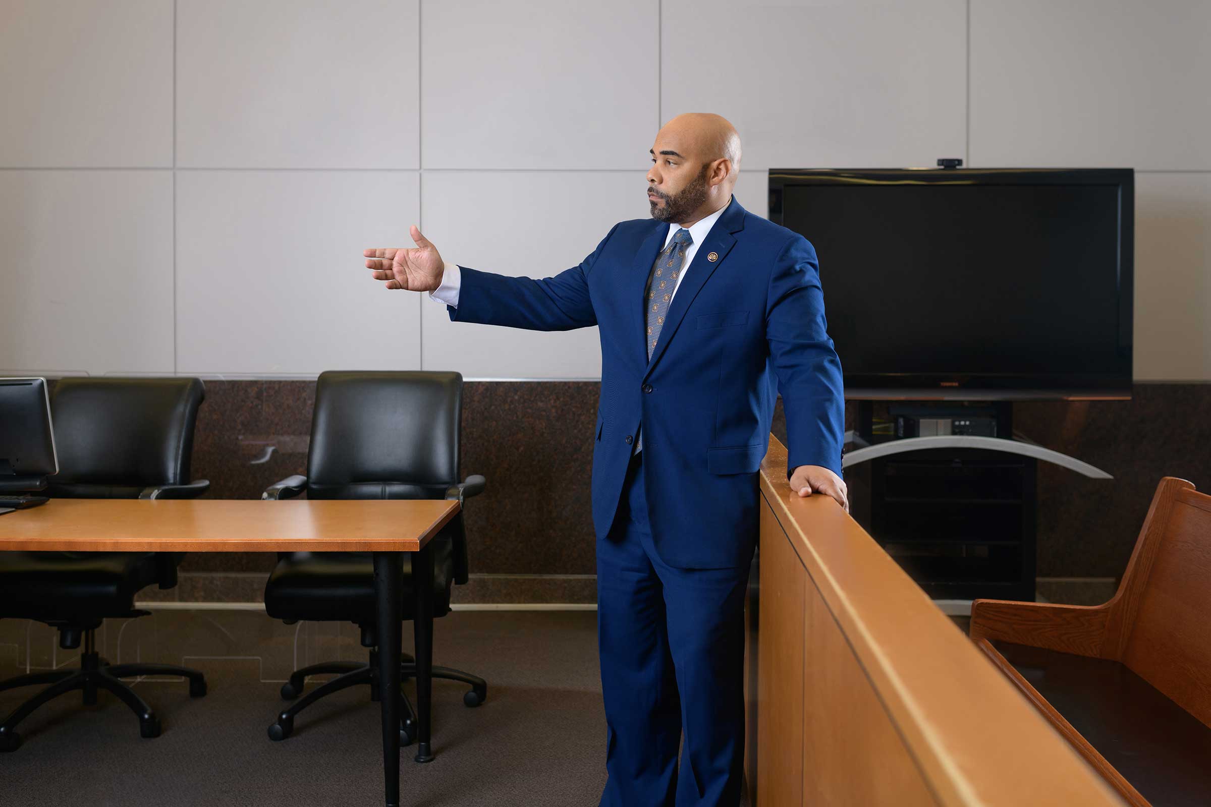 A man in a suit standing in a courtroom captured through the lens of Houston Photographer, Chris Spicks Photography.