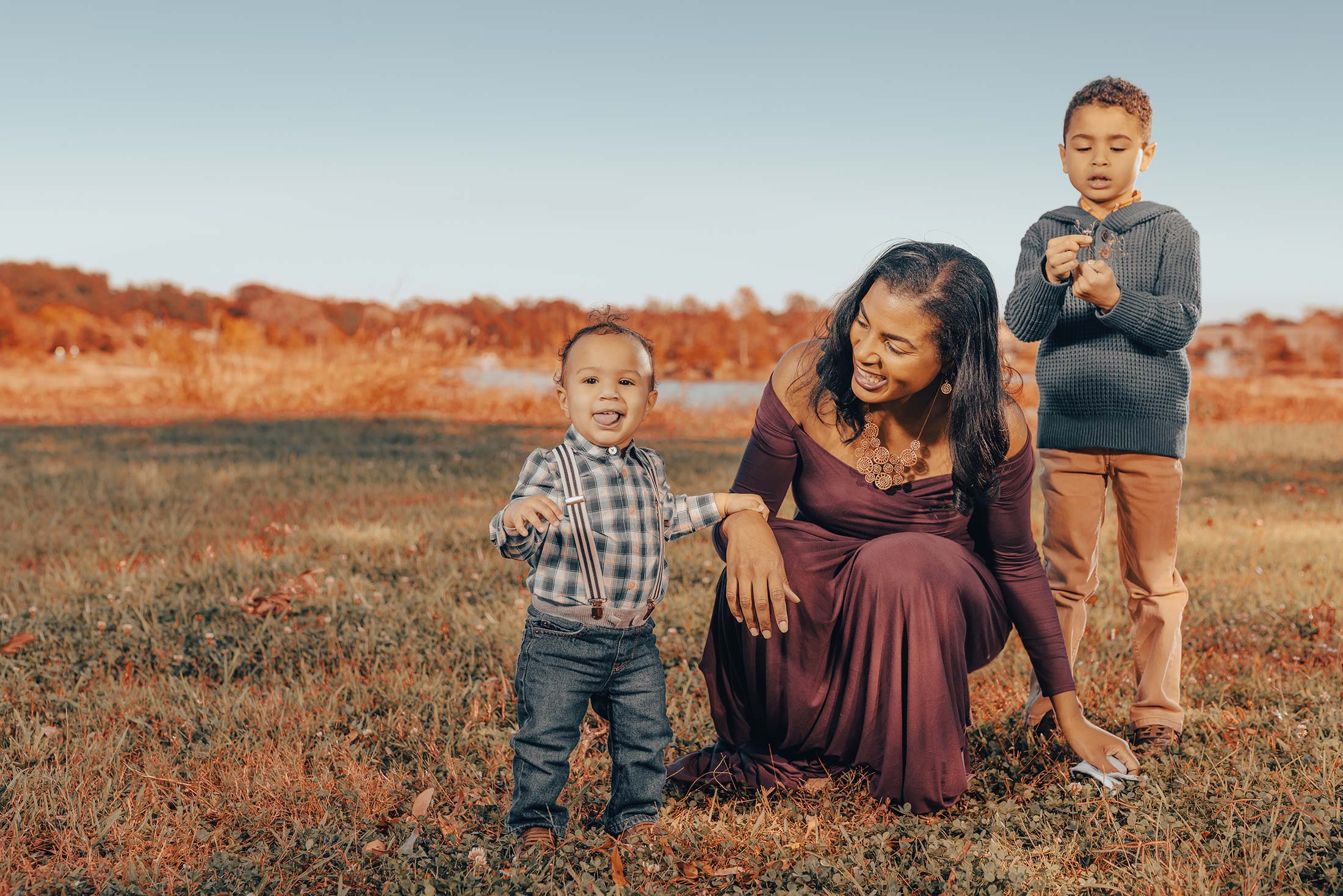 A family captures a creative moment in a field with their two small children, beautifully captured by Houston photographer, Chris Spicks Photography.