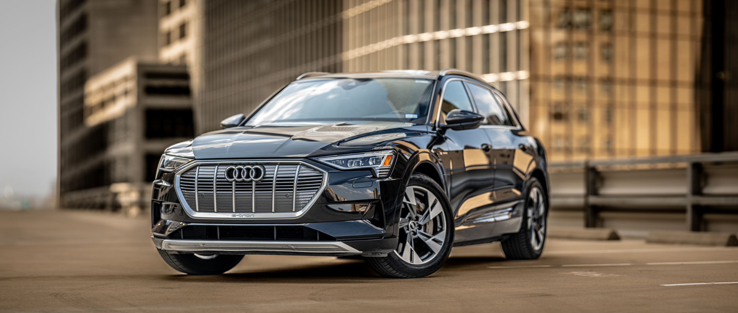 The 2020 Audi Q7 is parked in front of a city building, captured by Chris Spicks Photography, a Houston photographer known for his creative photography.