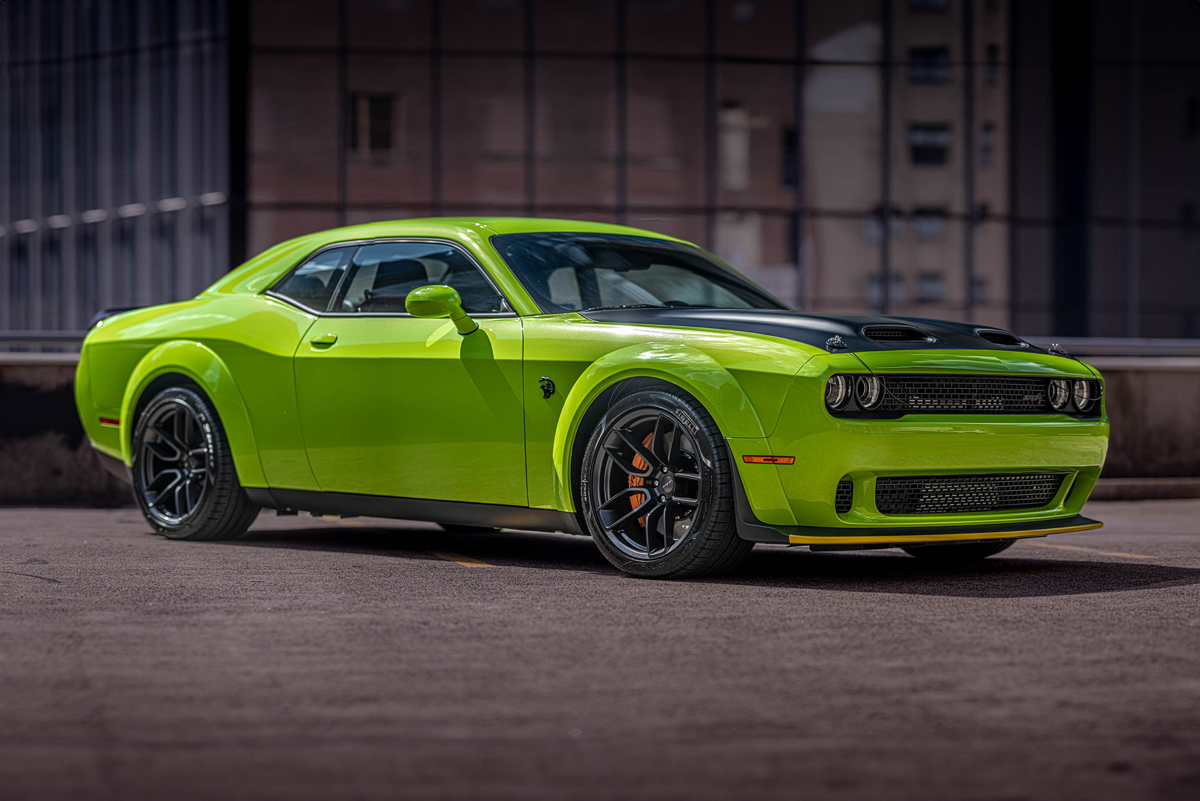 Bright green Dodge Challenger Hellcat on a rooftop in Downtown Houston parked at a 45 degree angle showing the passenger side.